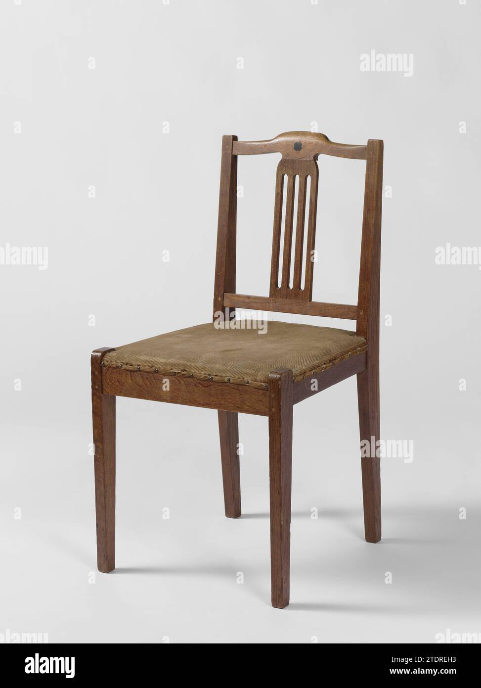 Chaise avec trois travaux ouverts dans la feuille centrale du dossier, 't Binnenhuis, c. 1900 - c. 1903 chaise Eikhout reposant sur quatre jambes rajeunissantes. Les pattes postérieures continuent dans les arrière-styles s'élargissant vers le haut. Les jambes sont interconnectées par des règles sur lesquelles repose la session. La crête surélevée au milieu contient un cercle mariné d'ébène et quatre plus petits cercles insérés de chêne kops. Entre le seuil supérieur et le seuil est un large style moyen dans lequel trois emplois ouverts ont travaillé. Le siège est recouvert de velours côtelé jaune -brun qui est fixé avec des clous. Chêne d'Amsterdam (bois). ébène (bois). corduroy Eik Banque D'Images