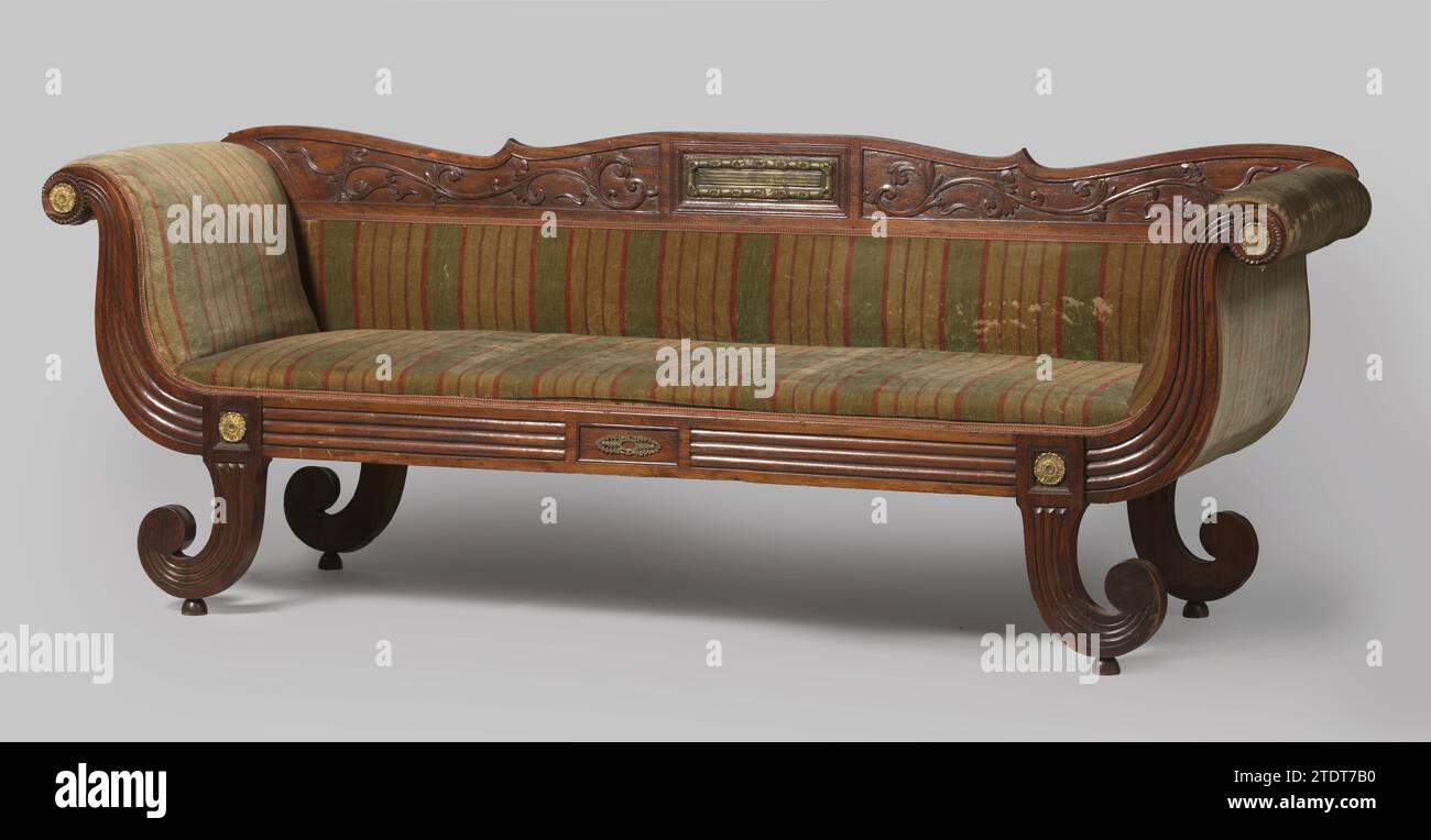 Canapé de Padoukhout avec pâte de laiton et avec garniture rayée vert-rouge, anonyme, 1825 - 1849 canapé de Padoukhout avec pâte de laiton et avec assise, dossier et murs recouverts de velours rayé vert-rouge. Le canapé repose sur quatre pattes pliées en forme de volute sur des boutons. La règle d'assise montre les maisons au-dessus des jambes et continue dans des styles latéraux en forme de volute. Le dos a un large seuil supérieur avec un dessus festonné. Les jambes avant, la règle d'assise et les styles latéraux sont côtelés à l'avant ; toutes les jambes ont un extérieur côtelé. Le rebord du dos est décoré de vignes à feuilles poignardées et a un rectang Banque D'Images