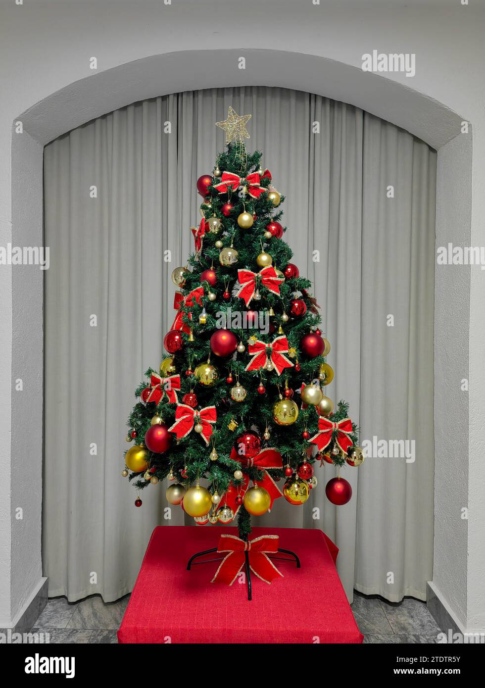 Élégance festive. Arbre de Noël dans le cadre de l'arche du hall. Banque D'Images