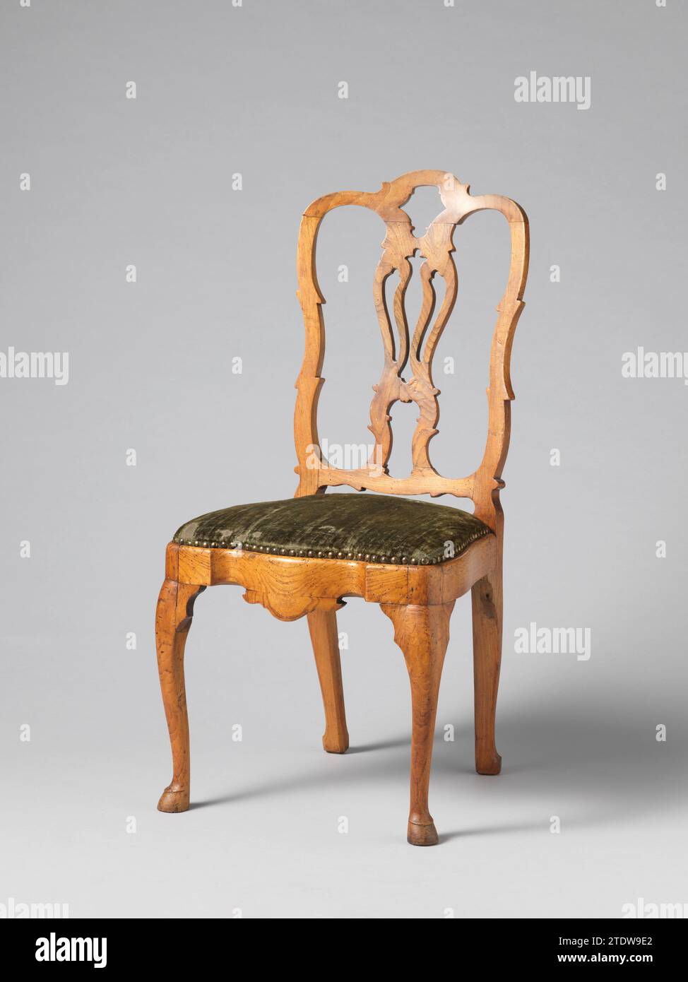 Chaise avec pressage de velours pressé avec un motif d'une tête d'homme louée, anonyme, 1785 - 1800 chaise d'acajou, recouverte de velours vert pressé, dans le dos avec un motif d'un médaillon entouré de vignes de feuilles, couronné par une guirlande. Dans le médaillon, une tête d'homme de profil. Les pattes carrées se rajeunirent ; les pattes postérieures sont en arrière. La pré-règle est courbée entre les pièces d'angle droit et, ainsi que le seuil supérieur, sous une guirlande, a une tête d'homme louée. Les seuils du dos trapézoïdal sont faiblement cornés. Pays-Bas septentrionaux Bois des pays-Bas (matériel végétal). acajou (bois). Chaise o Banque D'Images
