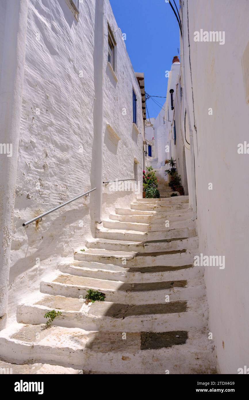 Pyrgos, GR - 6 août 2023 : rue dans un village grec traditionnel avec des maisons blanches et bleues blanchies à la chaux Banque D'Images