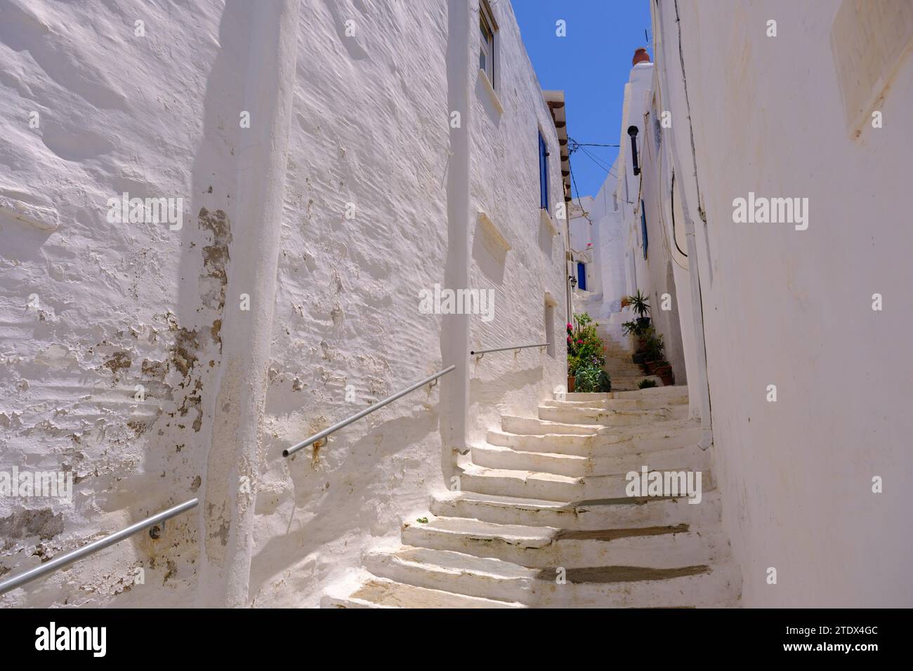 Pyrgos, GR - 6 août 2023 : rue dans un village grec traditionnel avec des maisons blanches et bleues blanchies à la chaux Banque D'Images