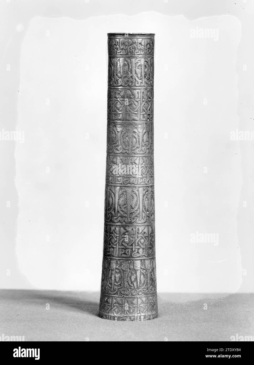 Tube avec neuf Frisons décorés, anonyme, c. 1175 - c. 1225 l'objet mené est tubulaire avec un bord au sommet. Il a une décoration piquée, gravée, qui est incrustée d'argent et est fourrée avec une pâte noire. Cet ornement se compose de neuf Frisons continus placés les uns au-dessus des autres avec des inscriptions en Kuelisch (?) Ecriture, les parties verticales des lettres sont entrelacées et finissent par des motifs de feuilles, ou sont droites et sortent sur un fond Arabesk. Avec le deuxième et le sixième frison, ce dernier se termine par des visages. Bronze Khurasan (métal). gravure argent (métal) / niello (techn Banque D'Images