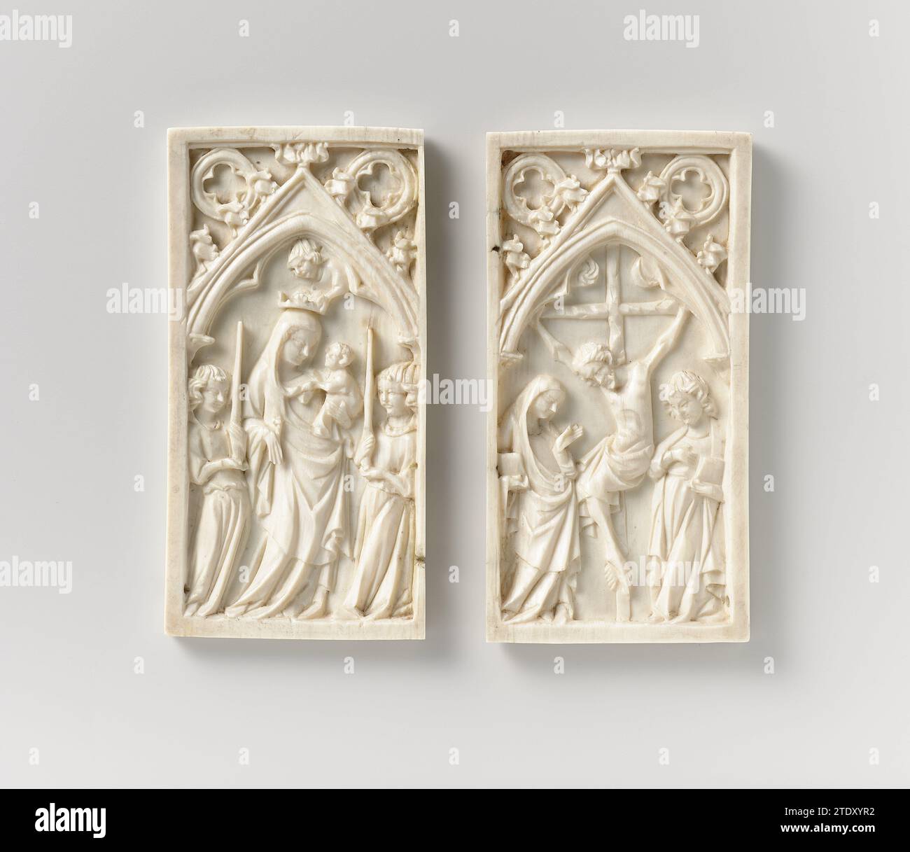 Diptyque avec la Vierge et l'enfant et la Crucifixion, anonyme, c. 1350 - c. 1400 sur l'aile gauche se dresse, sous un arc gothique pointu à trois lobes avec quatre passages dans le Zwikken, Maria entre deux cheveux -errant, flambeau -portant des anges. Elle a un lys dans la main droite et tient l'enfant sur le bras gauche, qui tient son voile d'une main et met son bras droit autour de son cou. Un ange tient une couronne au-dessus de la tête de Maria. Maria et Jean se tiennent sous la croix sur l'aile droite, au-dessus de laquelle soleil et lune. Les deux figures tiennent un livre en main, Marie fait un geste au Christ de la main gauche, Jean tient Banque D'Images