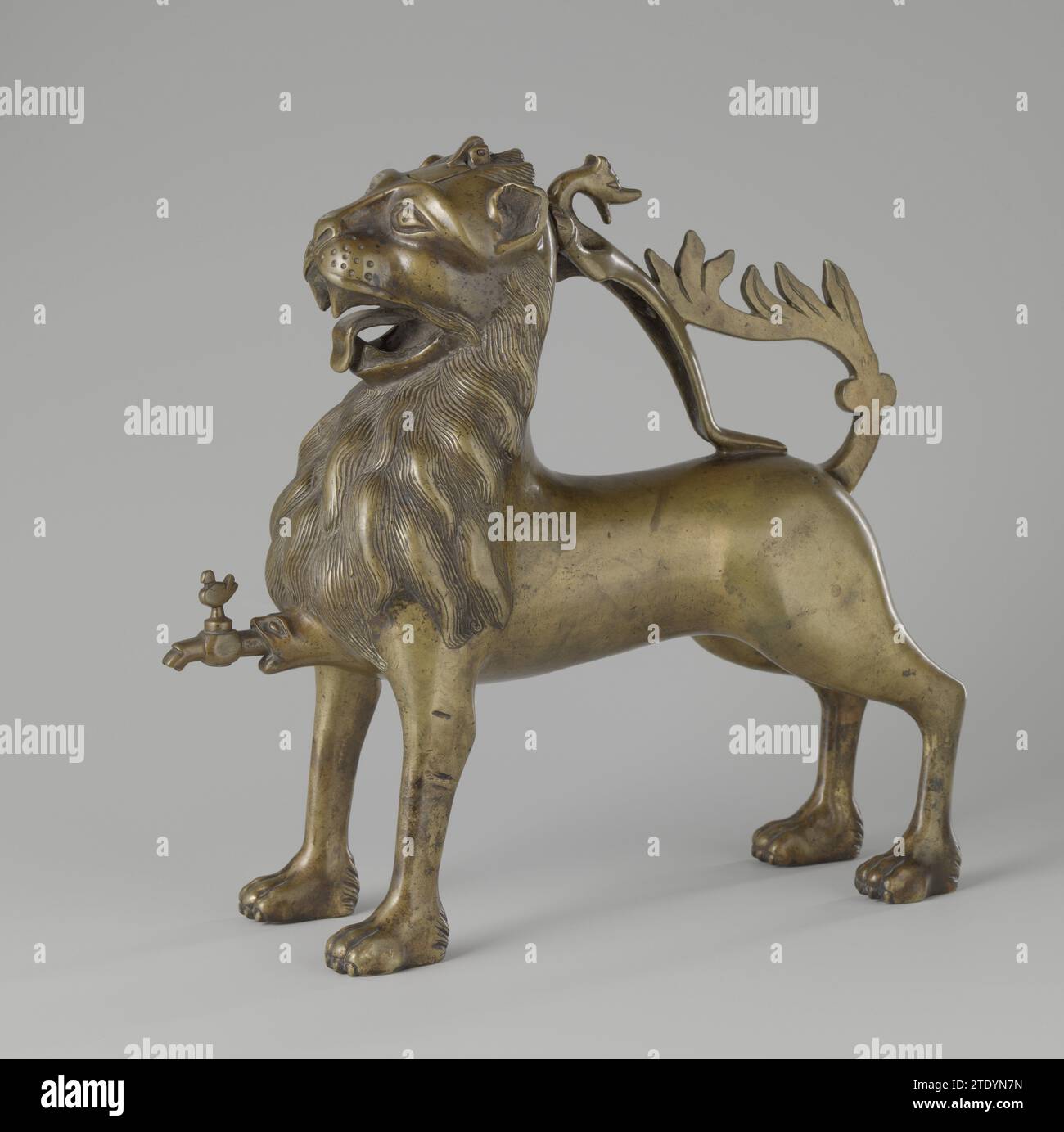 Aquamanile en forme de lion, anonyme, c. 1400 la technique du cire perdue et l'objet en grande partie accompagnant a la forme d'un lion, dont les détails (tels que la crinière, les yeux et la moustache) sont prolongés. De Leeuw a un dragon sur le dos, qui sert de poignée, et qui est relié à la queue du lion. Cela a légèrement retiré la tête, regarde vers l'avant et a ouvert la bouche, de sorte que la langue et quatre défenses sont visibles. La tête est modélisée de telle sorte que des lignes continues peuvent être observées du nez aux sourcils des oreilles. Dans la tête, un couvercle fixé à une charnière a été découpé pour remplir l'objet Banque D'Images