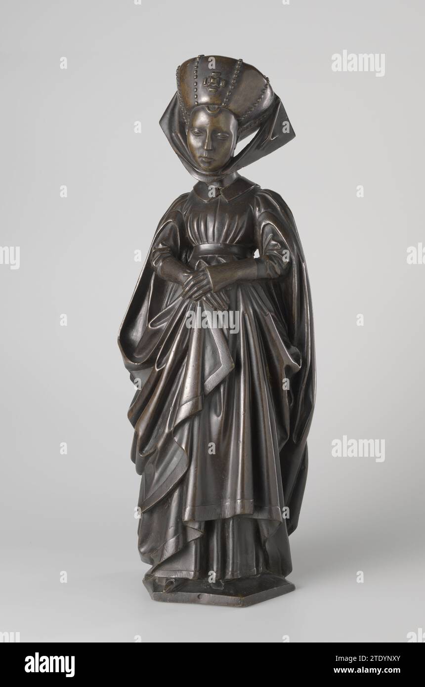 Dix balayeuses de la tombe d'Isabelle de Bourbon, atelier Borman (attribué à), renier van Thienen (I) (attribué à), c. 1475 - c. 1476 elle garde sa tête, dont les cheveux sont rasés autour du visage, légèrement à l'écart ; elle regarde devant elle-même. Elle tient la jupe de la Houppelande et une des deux tiges ornementales avec ses mains. La Houppelande maintenue autour de l'agent par une ceinture a un col de fourrure plat et de longues manches décoratives, qui, comme le bas de la jupe, sont déposées avec de la fourrure. Ci-dessous une robe, dont seules les manches serrées sont visibles, qui montrent de longs poignets de fourrure Banque D'Images