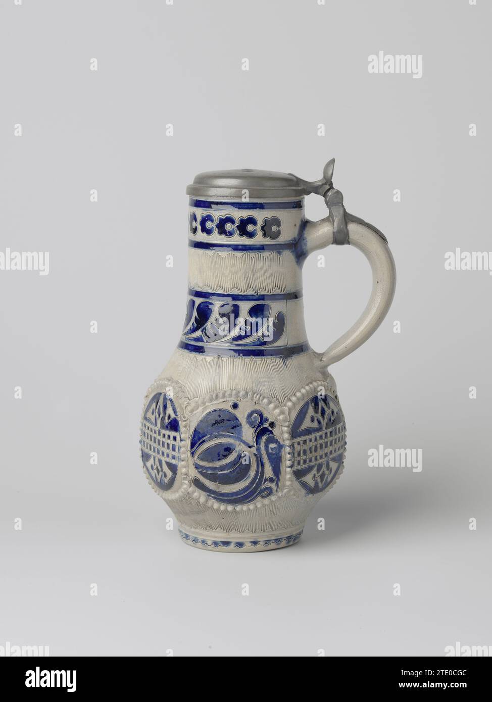 Cruche avec des fleurs stylisées, anonyme, c. 1730 - c. 1770 cruche en grès sur anneau de support avec un corps sphérique et un long col large. L'oreille en forme de C est fixée au cou et à l'épaule. Partiellement recouvert de bleu cobalt. Le ventre est hexagonal avec un compartiment rond de chaque côté formé par un pneu imprimé et posé de bulbes en relief. Dans les cours alternativement une entrée, décoration stylisée d'une fleur livel ou des plantes près d'une clôture. En dessous et au-dessus de cette décoration une bande avec une ligne en zigzag pressée (Knibis). Le cou est divisé en trois pneus avec des vignes à feuilles stylisées, des knibis ou des fleurs stylisées. A. Banque D'Images