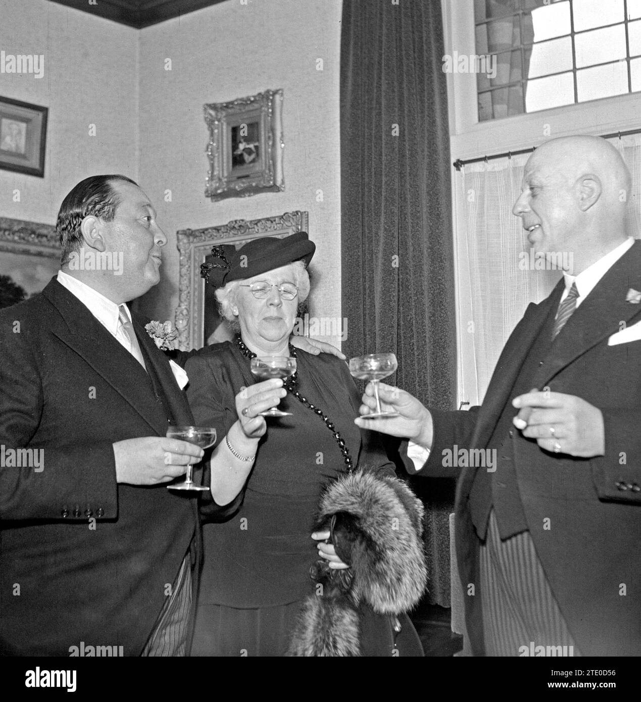 Directeur de l'usine Jan van Abbe (à gauche) en conversation avec un homme fumant le cigare et une femme ca. 1950 Banque D'Images