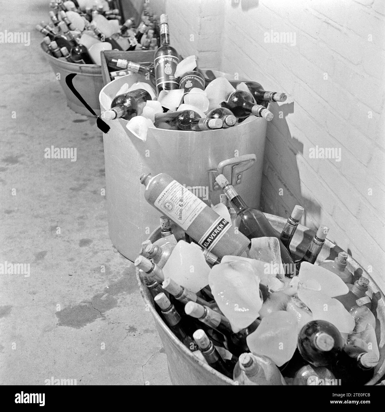 Bouteilles de liqueur, y compris un pot en pierre avec genever, refroidis dans des cuves avec de la glace ca. 1 janvier 1950 Banque D'Images