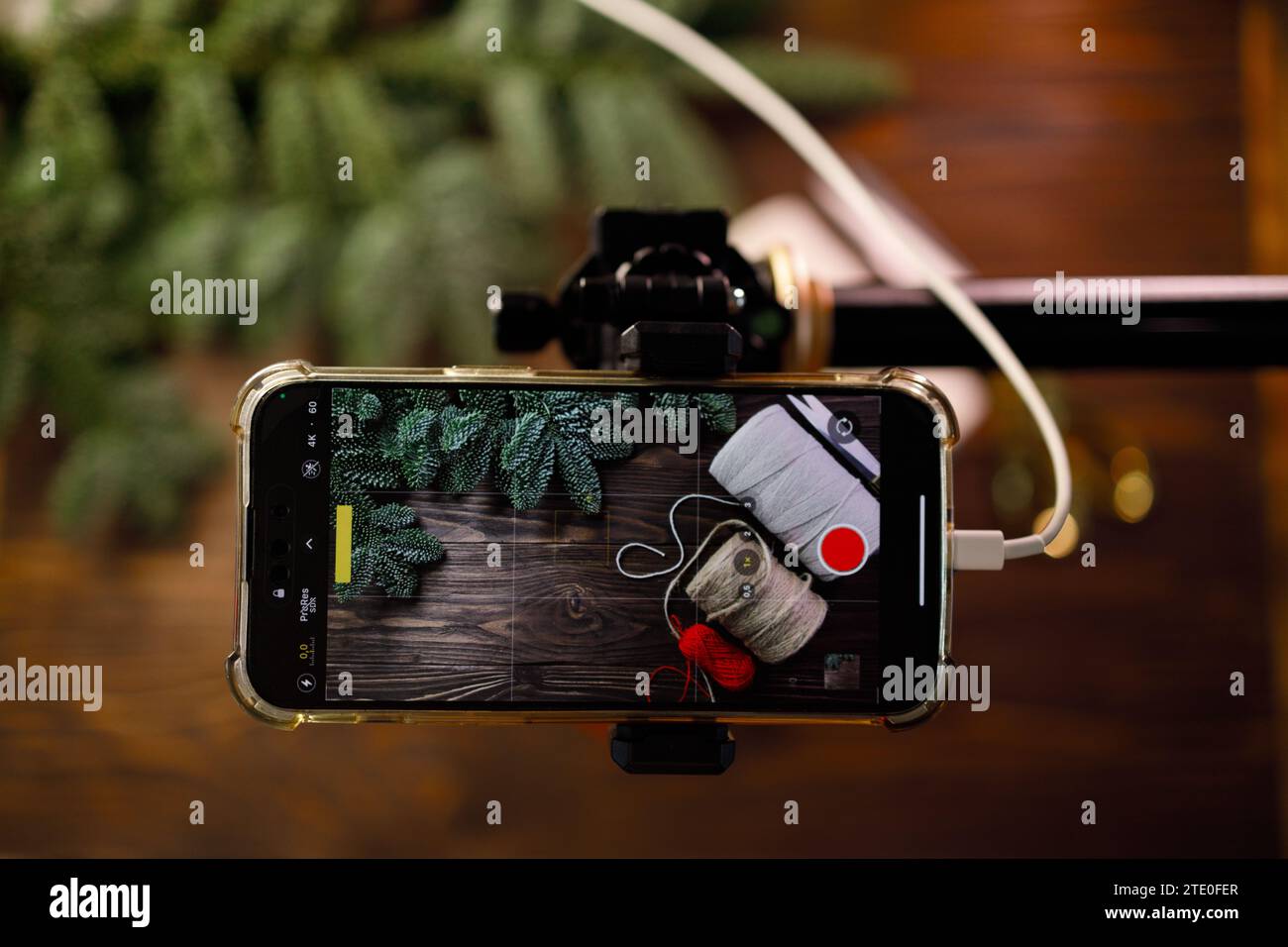 Photo ou vidéo de prise de vue de téléphone POV pour vlog avec des fournitures artisanales sur une table en bois décorée de branches d'épicéa Banque D'Images