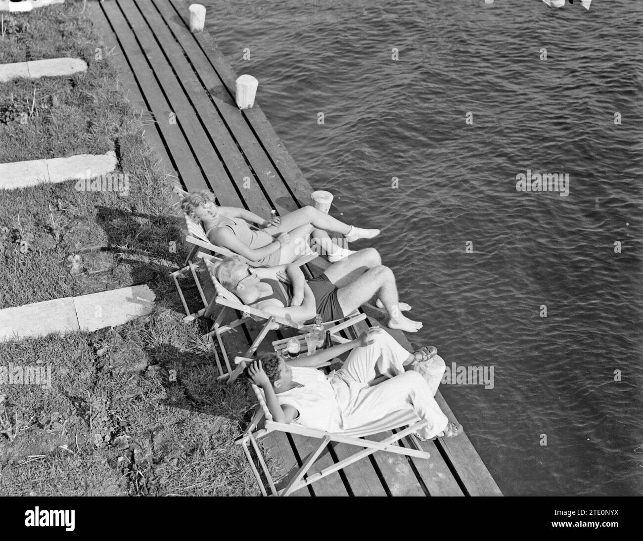Modèle Eva Waldschmidt, modèle Grummels et femme inconnue (de haut en bas) dans des chaises longues sur les rives de la Westeinderplassen ca. 1932 Banque D'Images