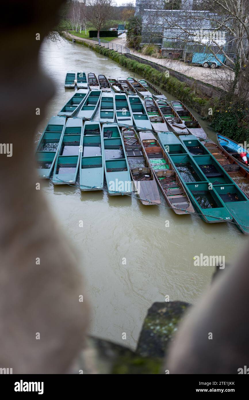 Punts à Magdalen Bridge, Oxford, Angleterre en hiver, avec la Tamise / Cherwell haute avec des eaux de crue. Un mélange de bateaux en bois et en fibre de verre. Banque D'Images