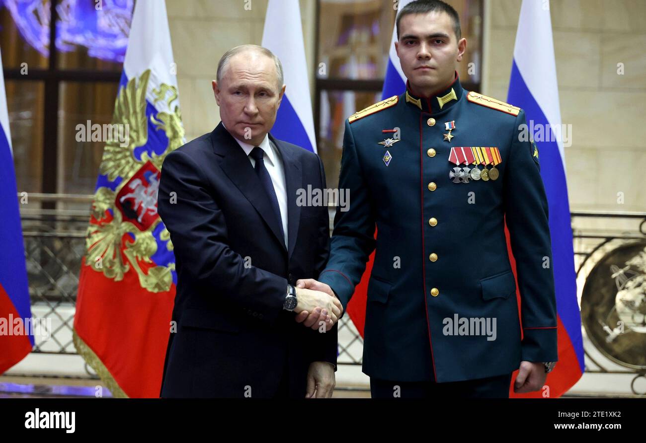 Moscou, Russie. 19 décembre 2023. Le président russe Vladimir Poutine, à gauche, serre la main du capitaine Ainur Safiullin après avoir remis la médaille d’or au Centre de contrôle de la Défense nationale, le 19 décembre 2023 à Moscou, en Russie. Crédit : Mikhail Klimentyev/Kremlin Pool/Alamy Live News Banque D'Images
