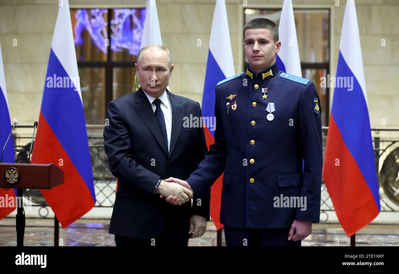 Moscou, Russie. 19 décembre 2023. Le président russe Vladimir Poutine, à gauche, serre la main du soldat Yevgeny Kudinov après avoir remis la médaille d’or au Centre de contrôle de la Défense nationale, le 19 décembre 2023 à Moscou, en Russie. Crédit : Mikhail Klimentyev/Kremlin Pool/Alamy Live News Banque D'Images