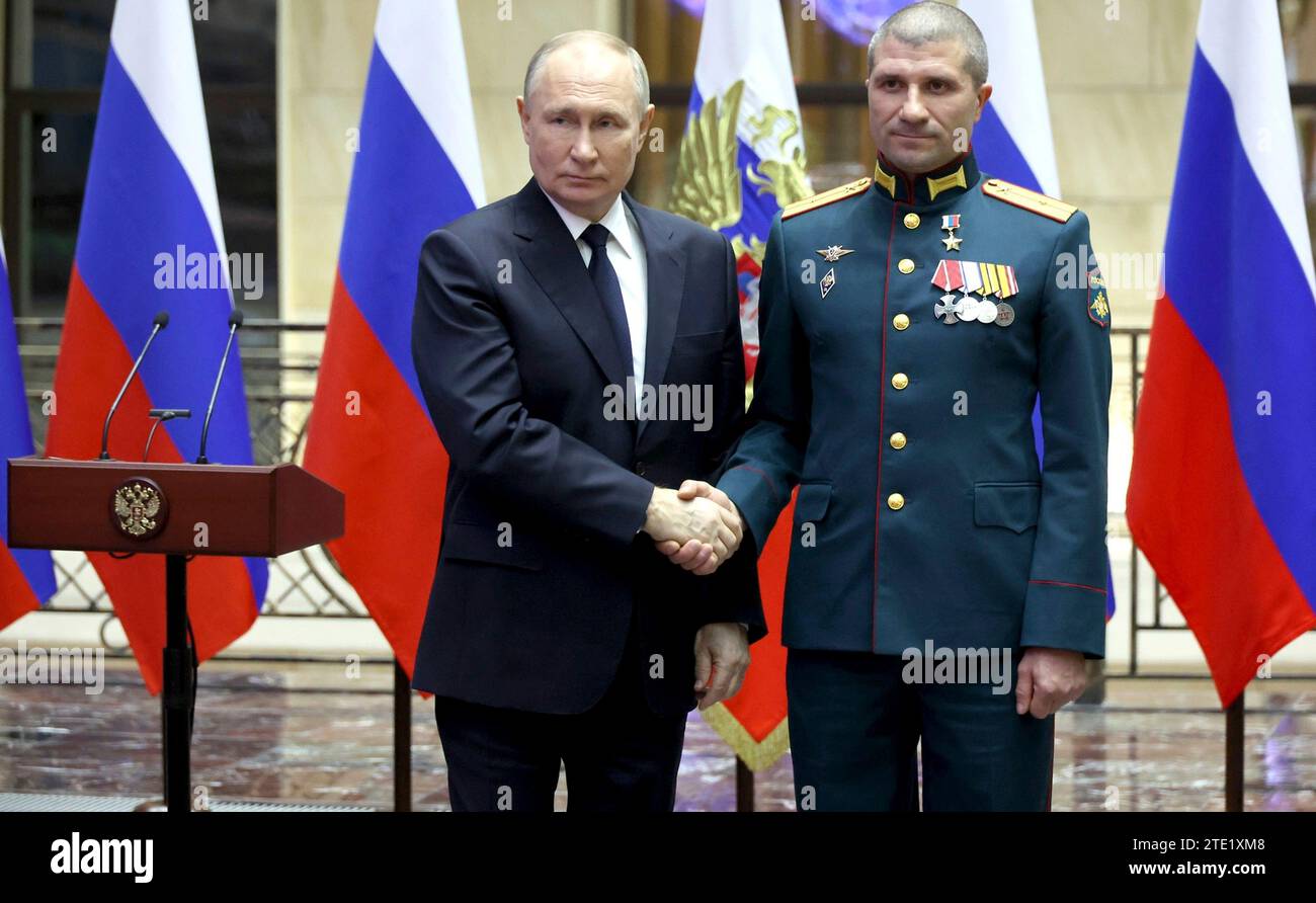 Moscou, Russie. 19 décembre 2023. Le président russe Vladimir Poutine, à gauche, serre la main du lieutenant Alexei Spesivtsev après avoir remis la médaille d’or au Centre de contrôle de la Défense nationale, le 19 décembre 2023 à Moscou, en Russie. Crédit : Mikhail Klimentyev/Kremlin Pool/Alamy Live News Banque D'Images