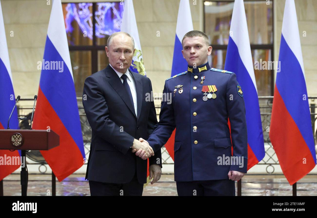 Moscou, Russie. 19 décembre 2023. Le président russe Vladimir Poutine, à gauche, serre la main du sergent junior Viatcheslav Matskevitch après avoir remis la médaille d’or au Centre de contrôle de la Défense nationale, le 19 décembre 2023 à Moscou, en Russie. Crédit : Mikhail Klimentyev/Kremlin Pool/Alamy Live News Banque D'Images