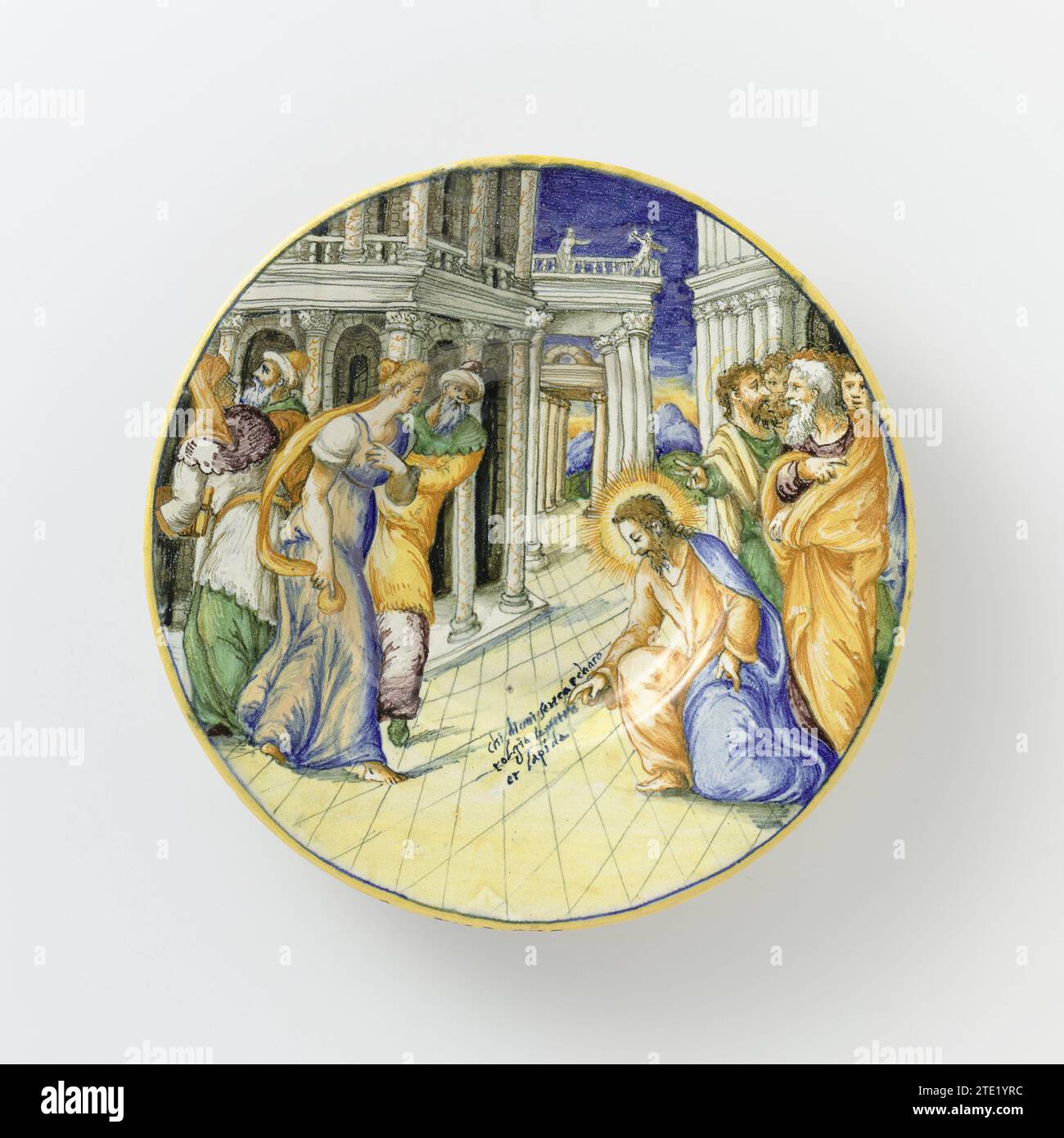 Plat avec Christ et la femme prise en adultère, anonyme, c. 1570 - c. 1580 plat rond de majolique peinte multicolore. Sur le plat une représentation du Christ avec la femme adultère. Entre les maisons à colonnes, un Christ agenouillé est peint à droite au premier plan qui écrit au sol avec sa main droite : Chi di VOI Senca P Chato // Tolgia la Pietra // et Lapida. Il y a quatre disciples derrière Christ. Sur la gauche au premier plan se trouve une femme et trois Farzeërs. Le texte est peint au dos du plat : I Faryi Armati di // Malicia Prentorno UNA // Presa in Allduterio ENAR Banque D'Images