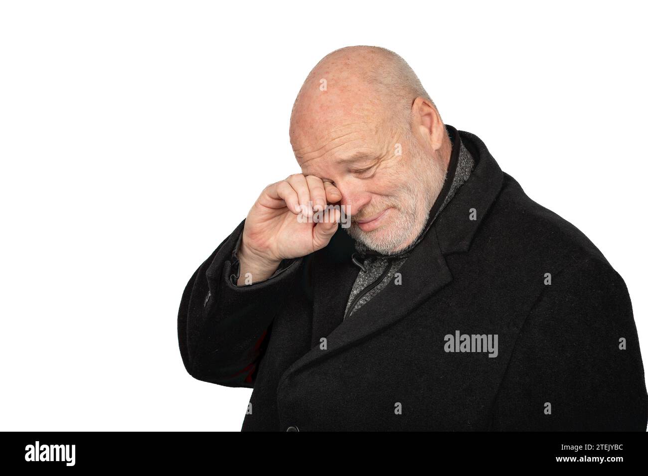 Triste homme de 58 ans en manteau d'hiver sombre pleurant sur fond blanc - concept émotionnel mature masculin Banque D'Images