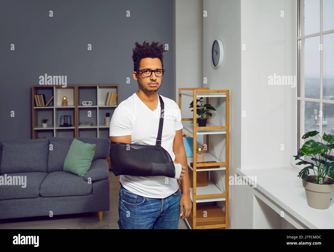 Jeune homme biracial avec bras cassé dans le bandage Banque D'Images