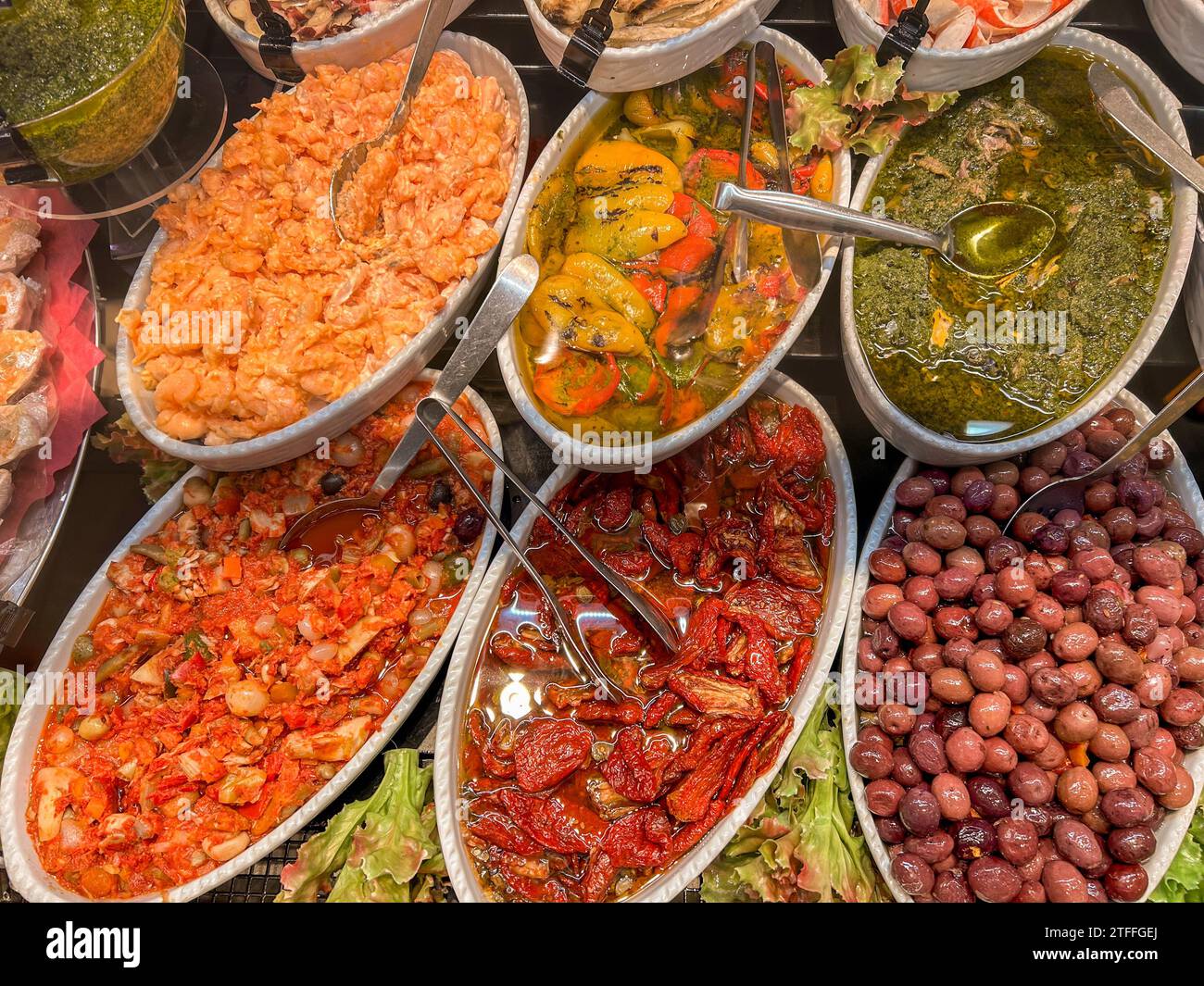 Plats cuisinés dans des plateaux, olives assaisonnées, tomates séchées au soleil à l'huile et salade de poivrons à l'huile d'olive, anchois avec sauce verte et crevettes avec Banque D'Images
