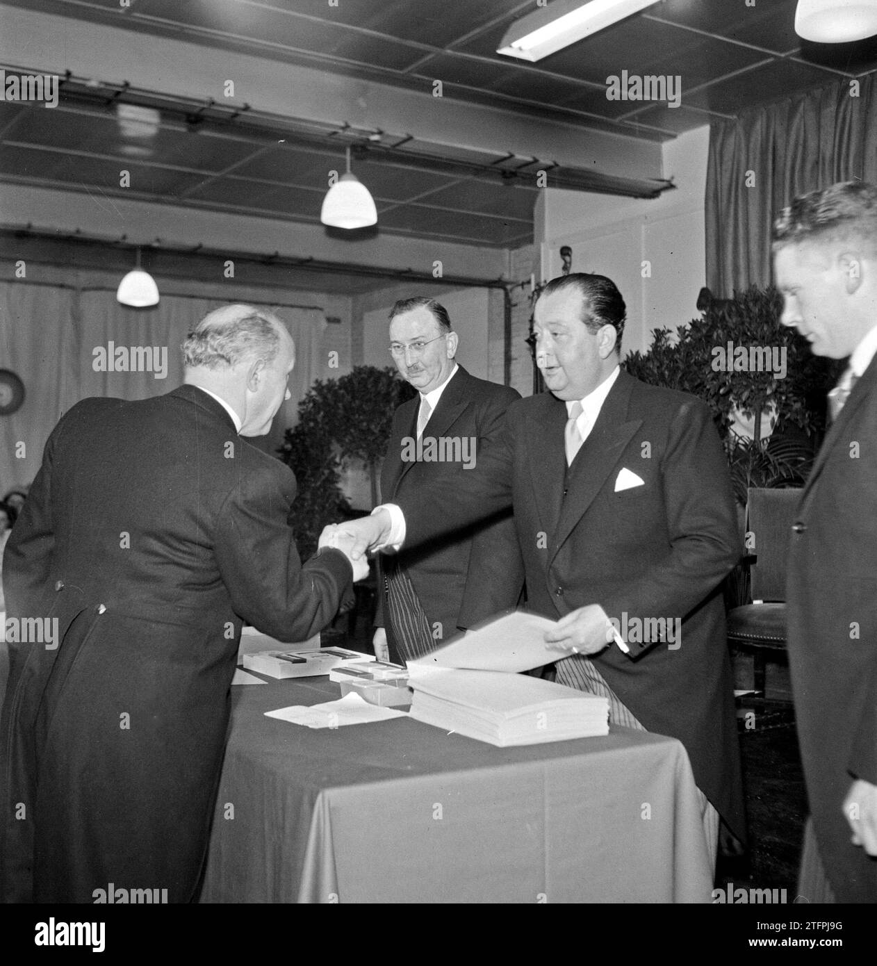 Le directeur de l'usine Jan van Abbe (à droite) serre la main d'un homme ca. 1950 Banque D'Images