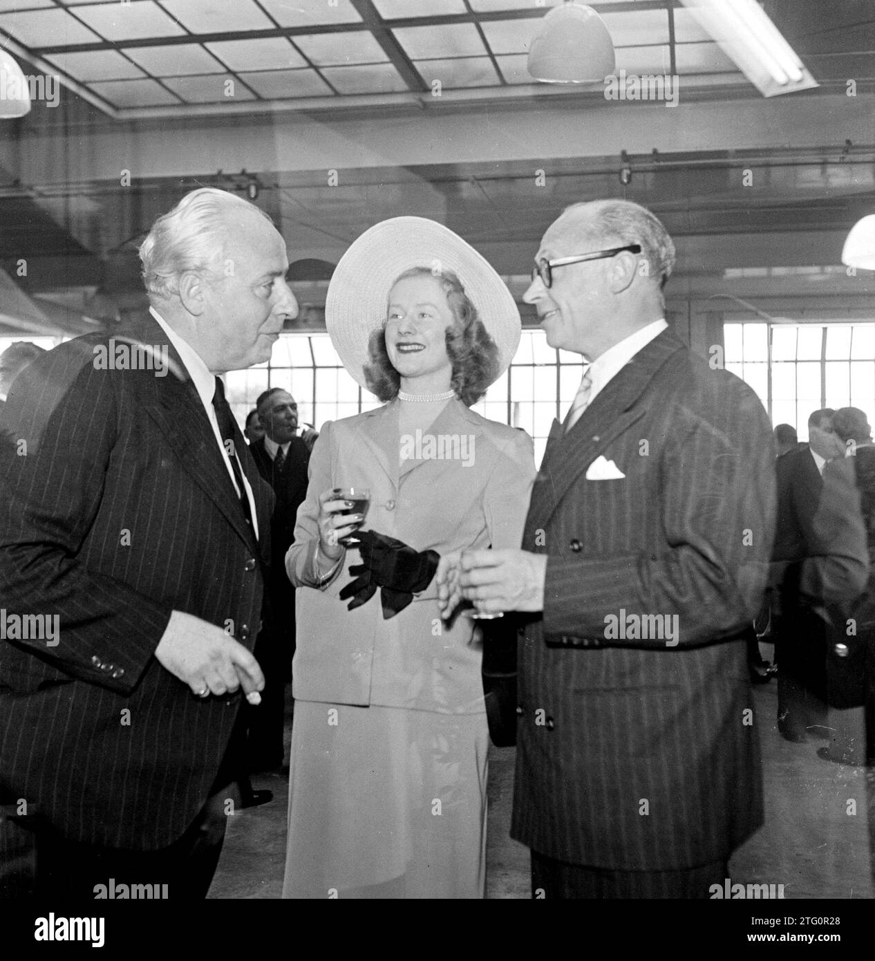 Photographe fumeur de cigares Willem van de Poll (à gauche) en conversation avec un homme et une femme ca. 1950 Banque D'Images