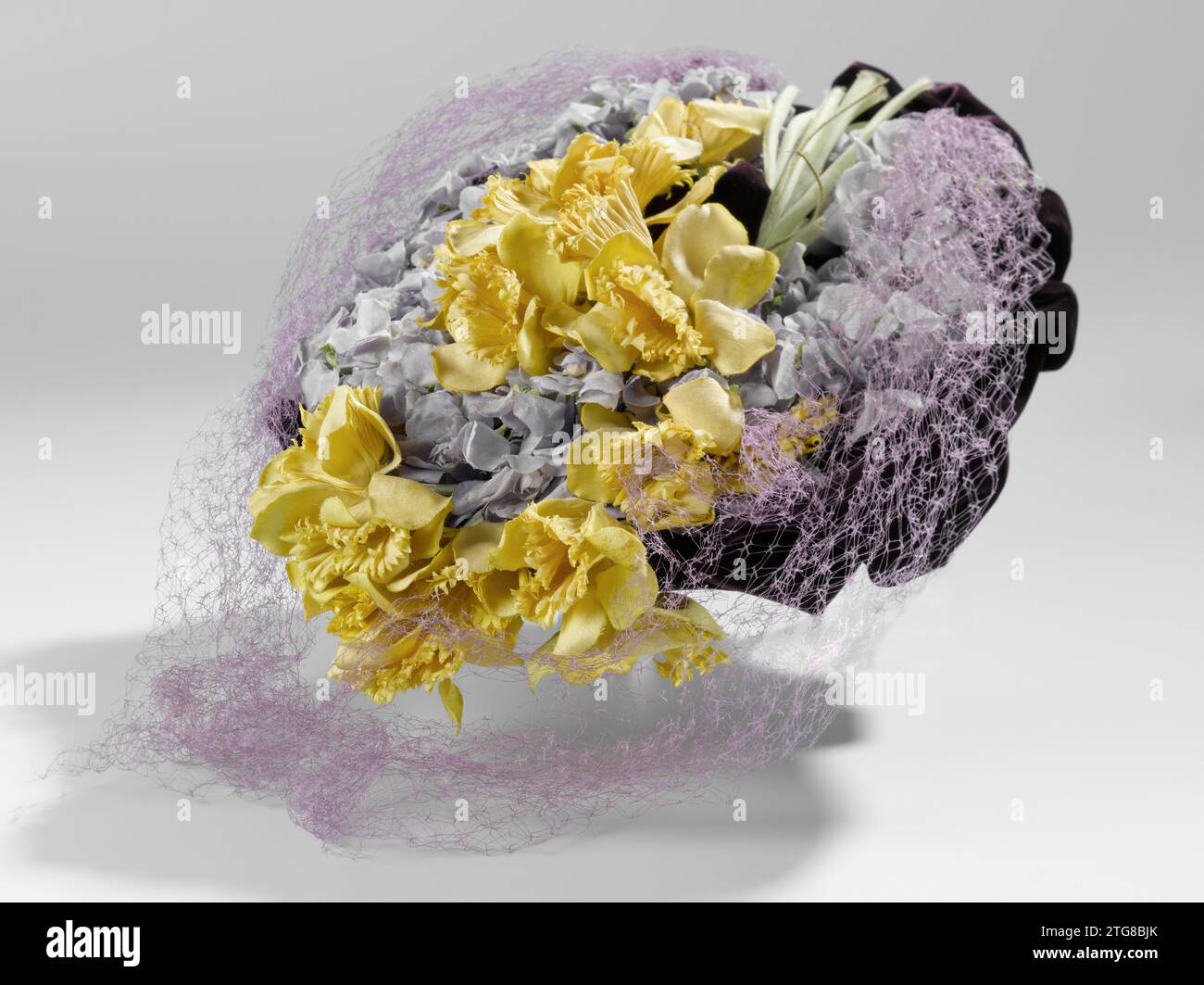 Grand béret aux jonquilles et violettes, Janette Colombier (atelier de), c. 1943 plat, haut béret de velours violet décoré de jonquilles jaunes et de violettes de Parme de coton et d'un voile à mailles grossières. Modèle : charnière vers l'avant avec une double bande recommandée à l'arrière. Intérieur de 'sparterie' (fibres végétales tressées) sur 'Tarlatan' (tissu de coton ouvert. Dans l'entrée fini avec ruban déchiré brun. Élastique double chapeau. Décorations : au milieu du chapeau, un bouquet de jonquilles jaunes est posé. Les tiges sont renforcées de laiton. Rond. Le chapeau un bord de 'violettes de Parme', abo Banque D'Images