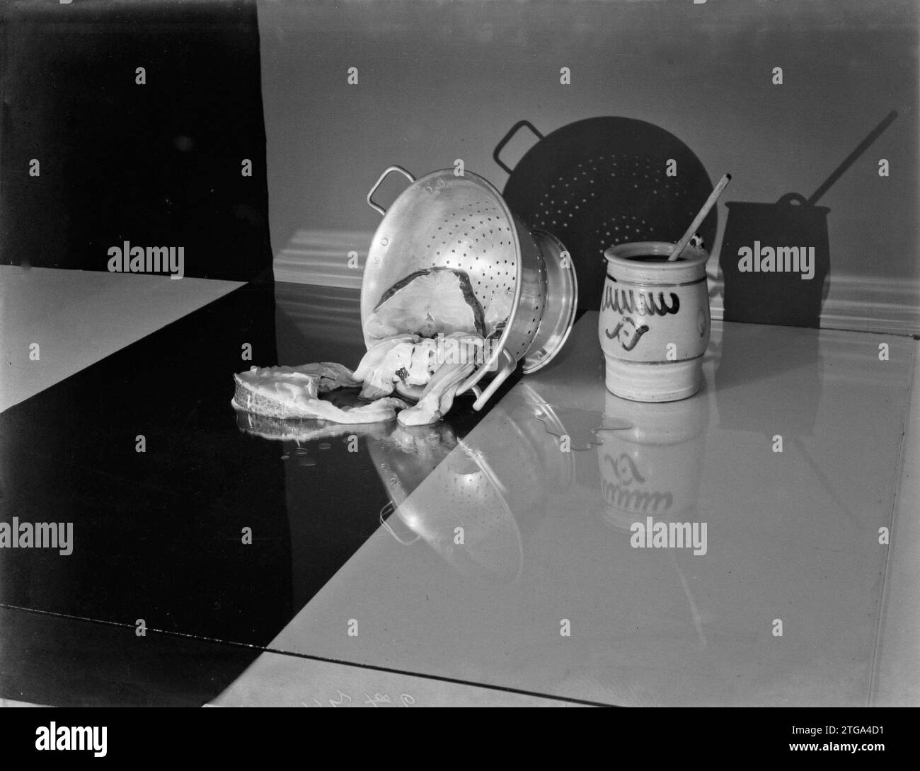 Nature morte des filets de morue dans une passoire avec un pot de Cologne de sel à côté de lui ca. 1933 Banque D'Images