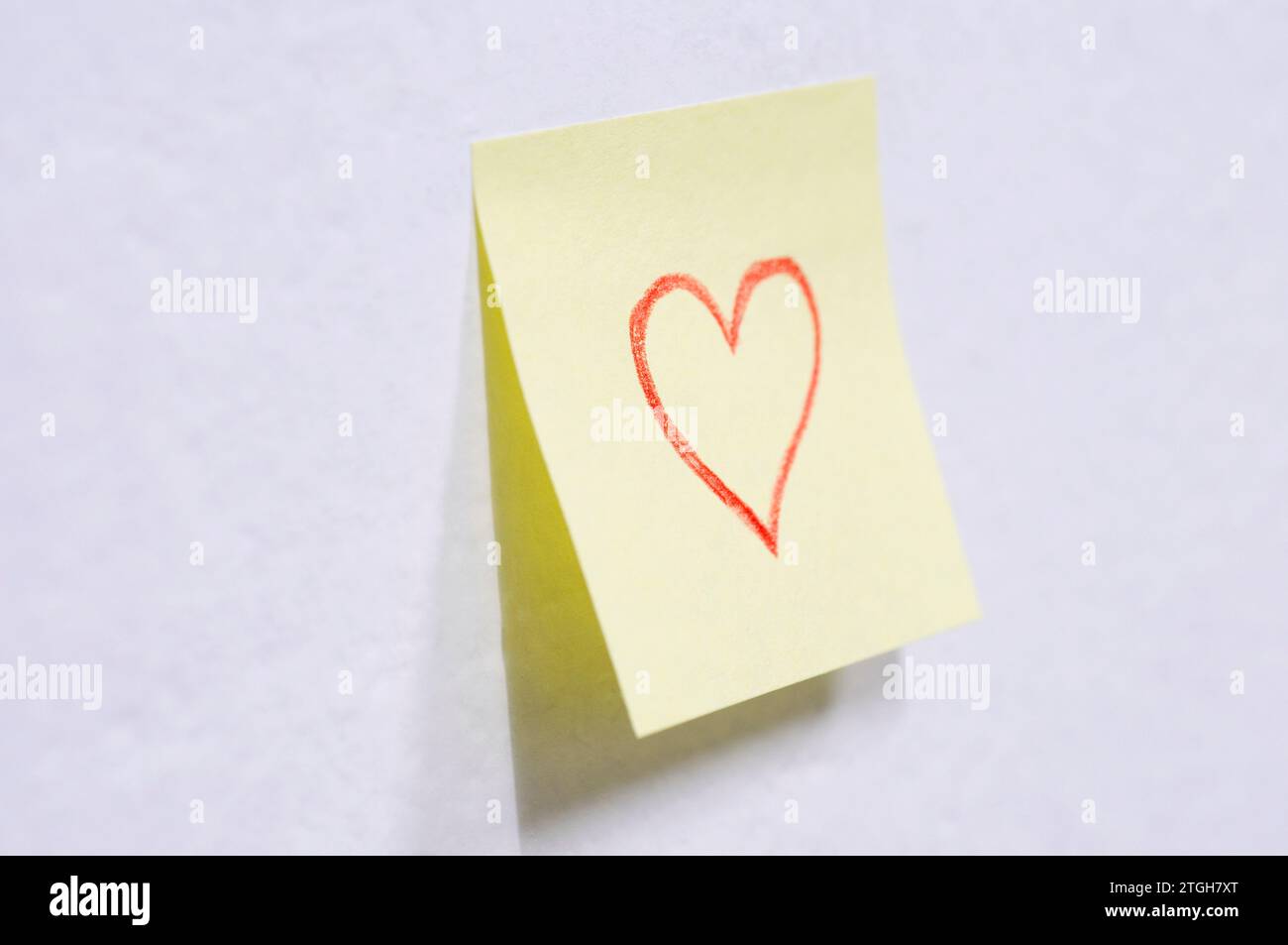 Post-it avec un dessin en forme de cœur sur le mur Banque D'Images