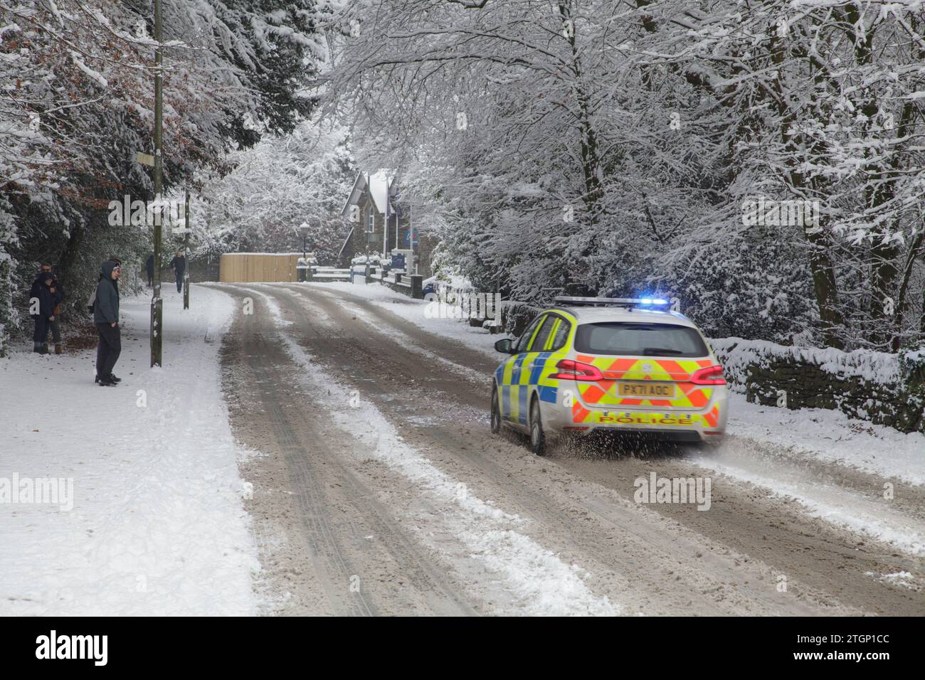 Une voiture de police circule sur des routes enneigées à Windermere, dans le Lake District, pendant une tempête hivernale Banque D'Images