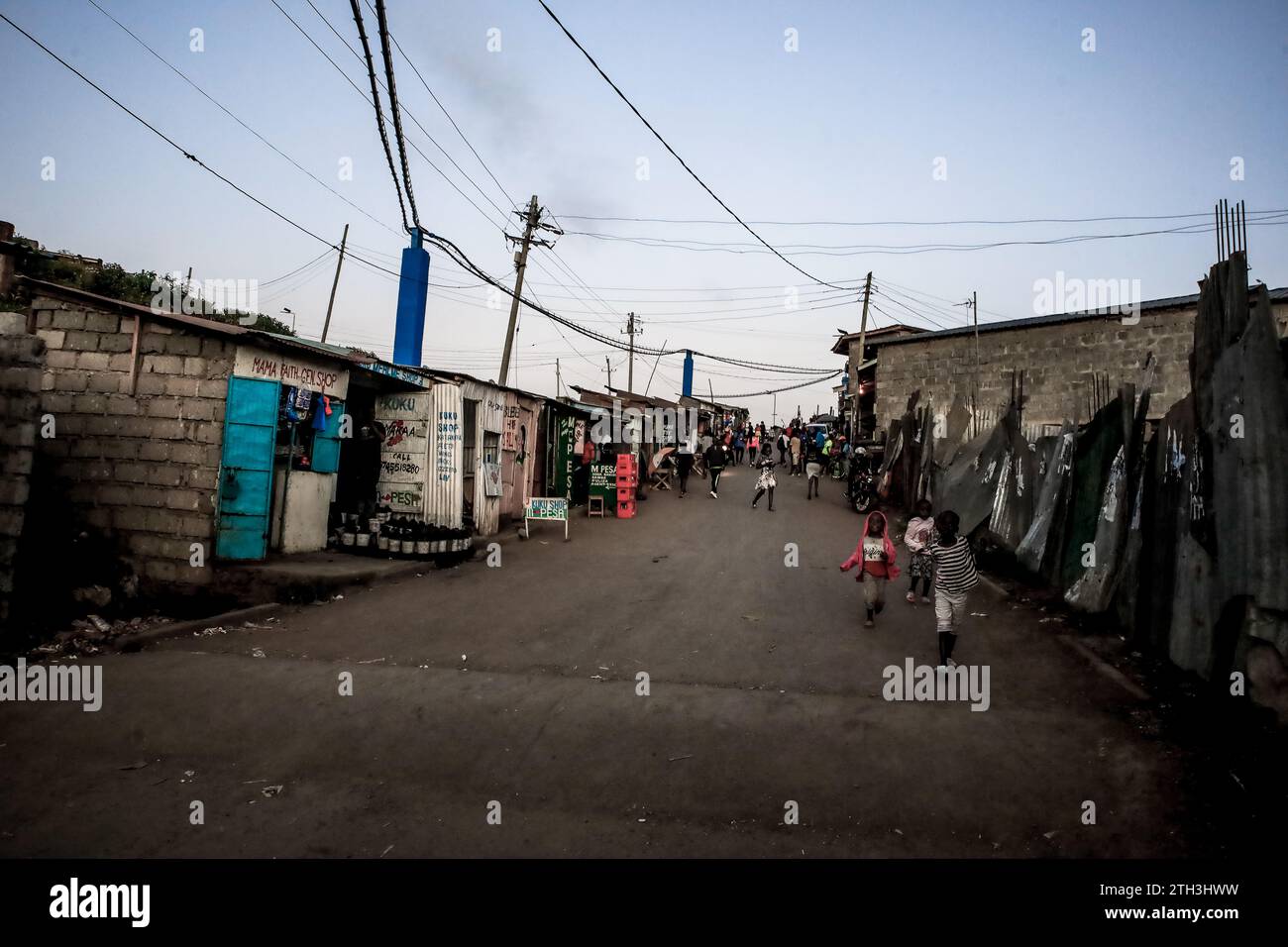 Les piétons passent devant les rues animées du bidonville de Kibera, Nairobi. Une vue à travers la vie quotidienne à Kibera actuellement le plus grand bidonville d'Afrique et le jour Banque D'Images