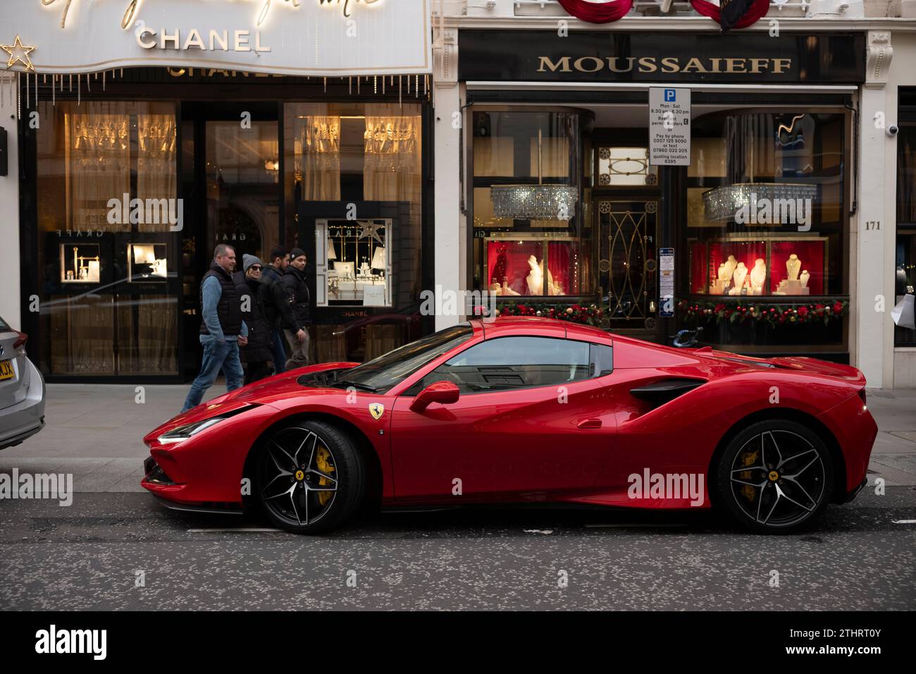 Super voitures dont une Ferrari rouge le long de Old Bond Street au cœur de Mayfair à Londres avant Noël 2023. Banque D'Images