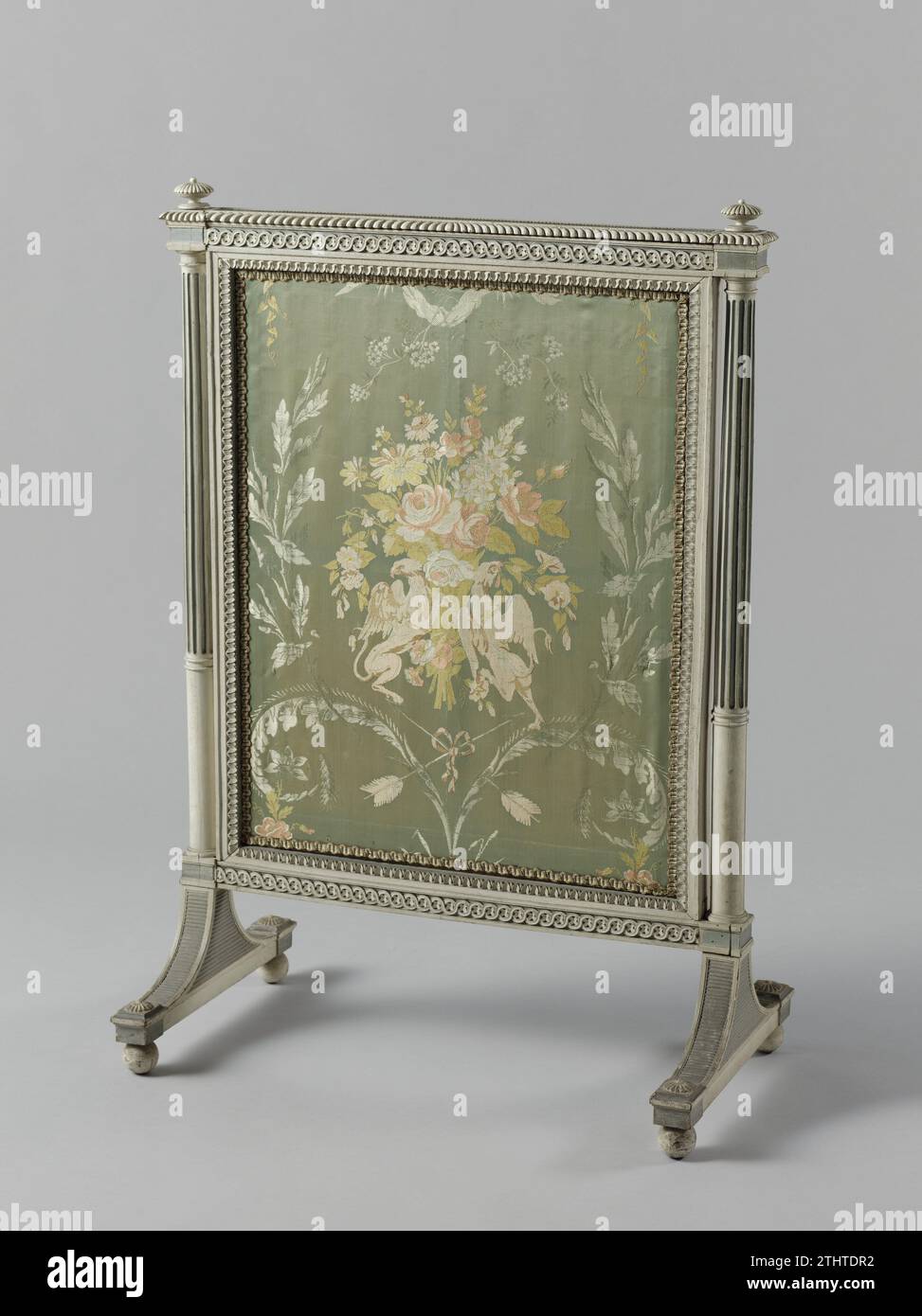 Pare-feu, anonyme, c. 1793 - c. 1795 pare-feu du Kopseulement, avec une plaque extensible. Le rembourrage montre un bouquet au milieu de motifs floraux sur un sol satiné bleu clair et tenu par deux griffons ; ci-dessous se trouvent des flèches croisées avec un arc. L'écran repose sur une base à double courbure et a détaché des colonnes toscanes avec lisse inférieur et tancidded au-dessus de l'arbre sur les coins. Seuils avec tresse à couteau. Venant du bâtiment Nieuwe Gracht 74, Haarlem. Voir BK-15615-A/P, 15614 et 15616-A. Travailleur du meuble : NetherlandsConcepteur : bois d'Amsterdam (matière végétale). hêtre (bois). soie. peinture ( Banque D'Images