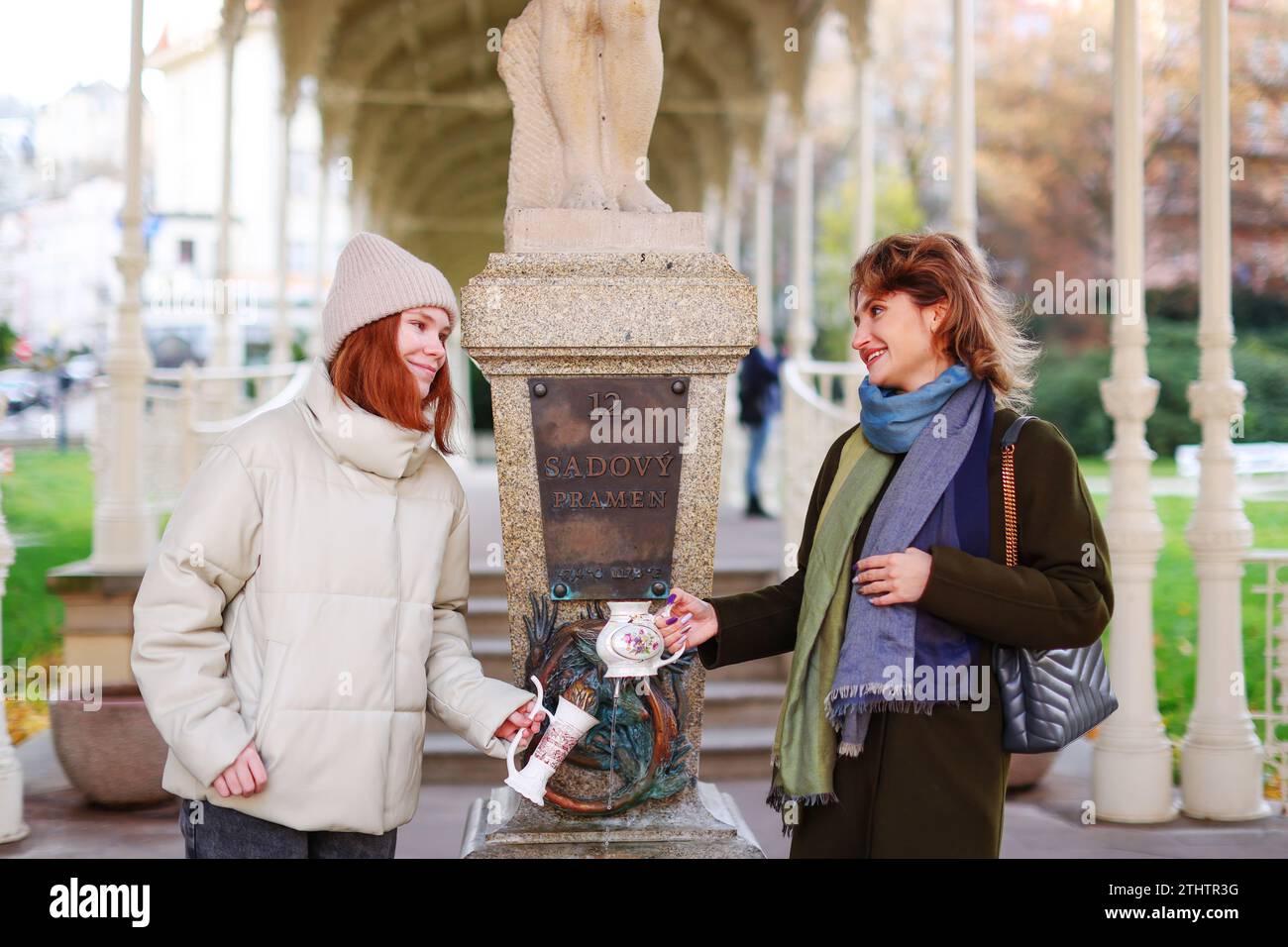 Deux filles boivent de l'eau minérale de Snake Spring dans la station balnéaire Karlovy Vary Banque D'Images