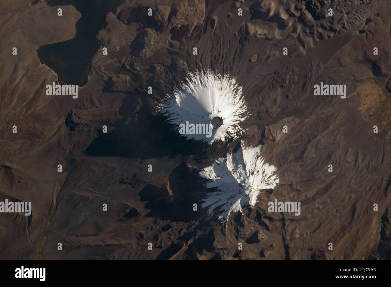 Les stratovolcans Parinacota et Pomerape (de haut en bas) vus depuis la Station spatiale internationale alors qu'il orbitait à 263 miles au-dessus du Chili, en Amérique du Sud. Parinacota est un volcan dormant à la frontière Chili-Bolivie et son pic est d'environ 20 800 pieds. Pomerape, dernière activité il y a plus de 100 000 ans, est également à la frontière Chili-Bolivie avec une altitude d'environ 20 600 pieds. En haut à gauche, se trouve le lac Chungar‡ dans le nord du Chili qui repose à environ 14 800 pieds au-dessus du niveau de la mer. Crédit image : NASA Banque D'Images