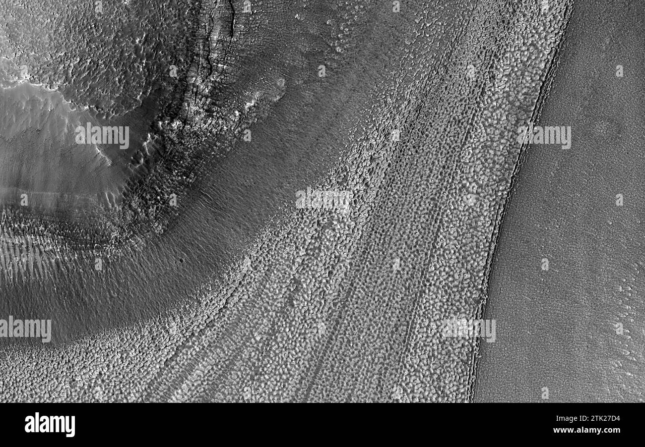 Espace. 20 août 2023. La surface de Mars est jonchée d'exemples de reliefs ressemblant à des glaciers. Alors que les dépôts de glace de surface sont principalement limités aux calottes polaires, les modèles d'écoulement lent et visqueux abondent dans de nombreuses régions non polaires de Mars. Les lignes de ruissellement qui apparaissent comme des crêtes linéaires dans les sols de surface et les débris rocheux sont souvent exposées au-dessus des dépôts de remplissage qui recouvrent les fonds des cratères et des vallées. Nous voyons de tels modèles sur les surfaces des glaciers glacés de la Terre et des glaciers rocheux recouverts de débris. Alors que la glace descend, la roche et le sol sont arrachés du paysage environnant et transportés le long de la coulée Banque D'Images