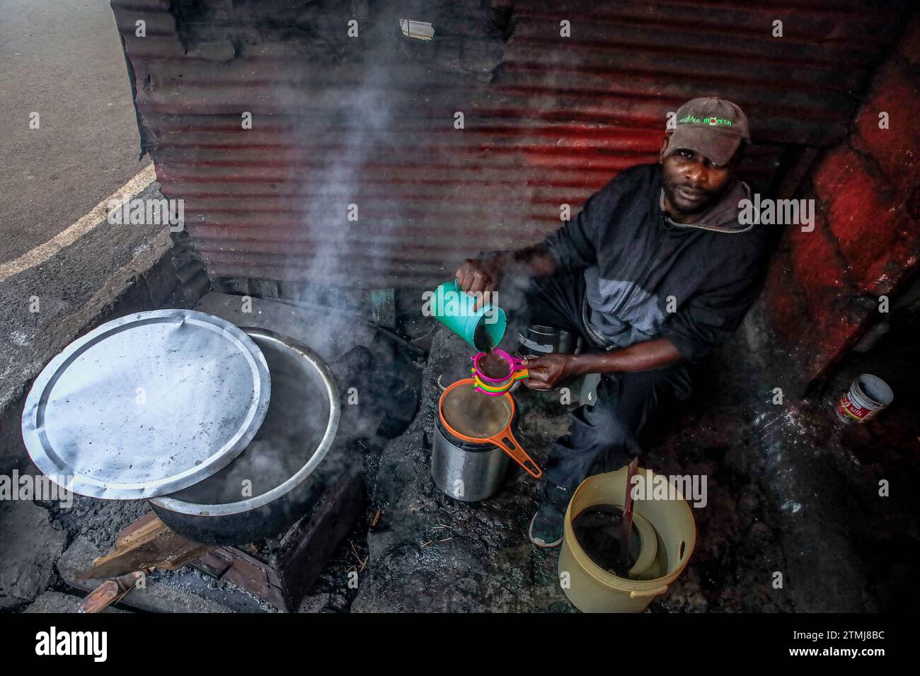 Un vendeur de café prépare un café chaud du soir dans sa boutique du bidonville de Kibera, Nairobi. Une vue à travers la vie quotidienne à Kibera actuellement le plus grand d’Afrique Banque D'Images