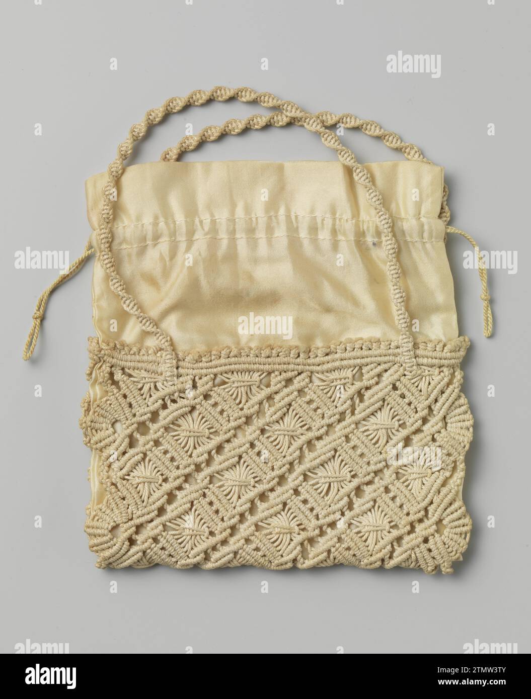 Sac dans un modèle plat, rectangulaire, en macramé de coton de couleur crème avec une doublure en satin de couleur crème, anonyme, c. 1920 sac dans un modèle plat, rectangulaire, dont la moitié inférieure est en macramé de coton de couleur crème, qui est lié dans un motif de travaux diagonaux. Des deux côtés une poignée de Macramé, qui est attachée de sorte qu'il obtient une forme d'hélice. Le sac est doublé d'un satin couleur crème, qui dépasse partiellement au-dessus de la partie nouée. Un tunnel est cousu sur le côté, de sorte qu'un cordon tordu de couleur crème est enfilé. Pays-Bas entier : coton (textile). Doublure : Sac en soie dans un modèle plat et rectangulaire, le Banque D'Images