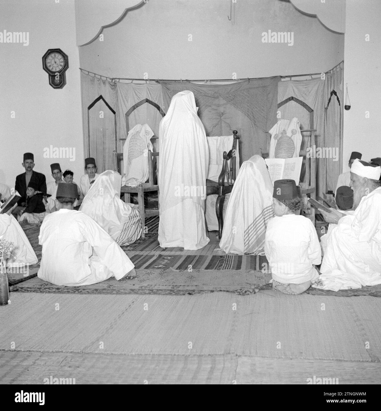 Un groupe de Samaritains dans leur maison de prière lisant leurs écritures (parchemin de prière) ca. 1950-1955 Banque D'Images