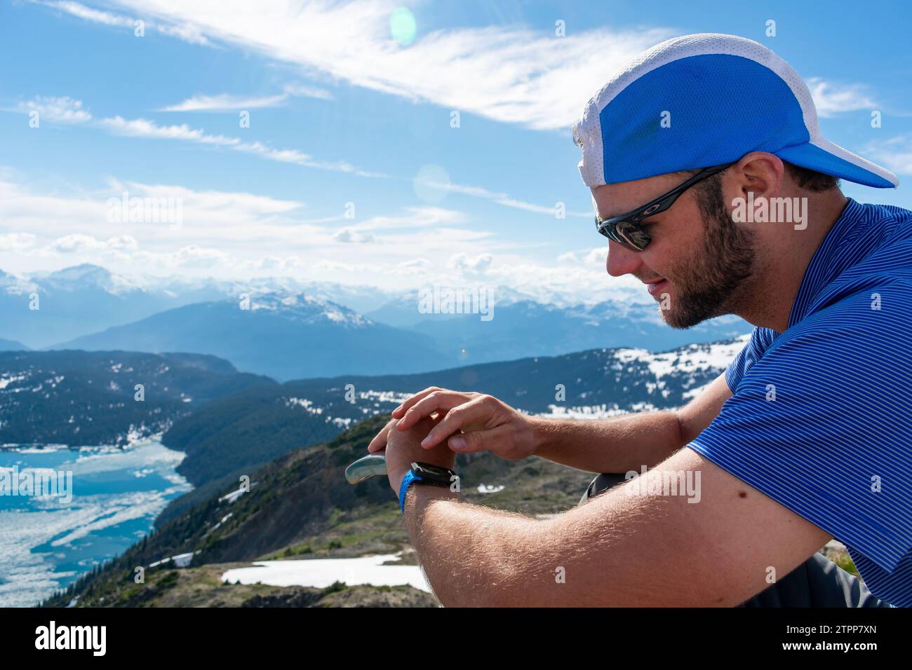 Randonneur ajuste la montre GPS sur Panorama Ridge avec les montagnes au-delà. Banque D'Images Randonneur ajuste la montre GPS sur Panorama Ridge avec les montagnes au-delà. Banque D'Images