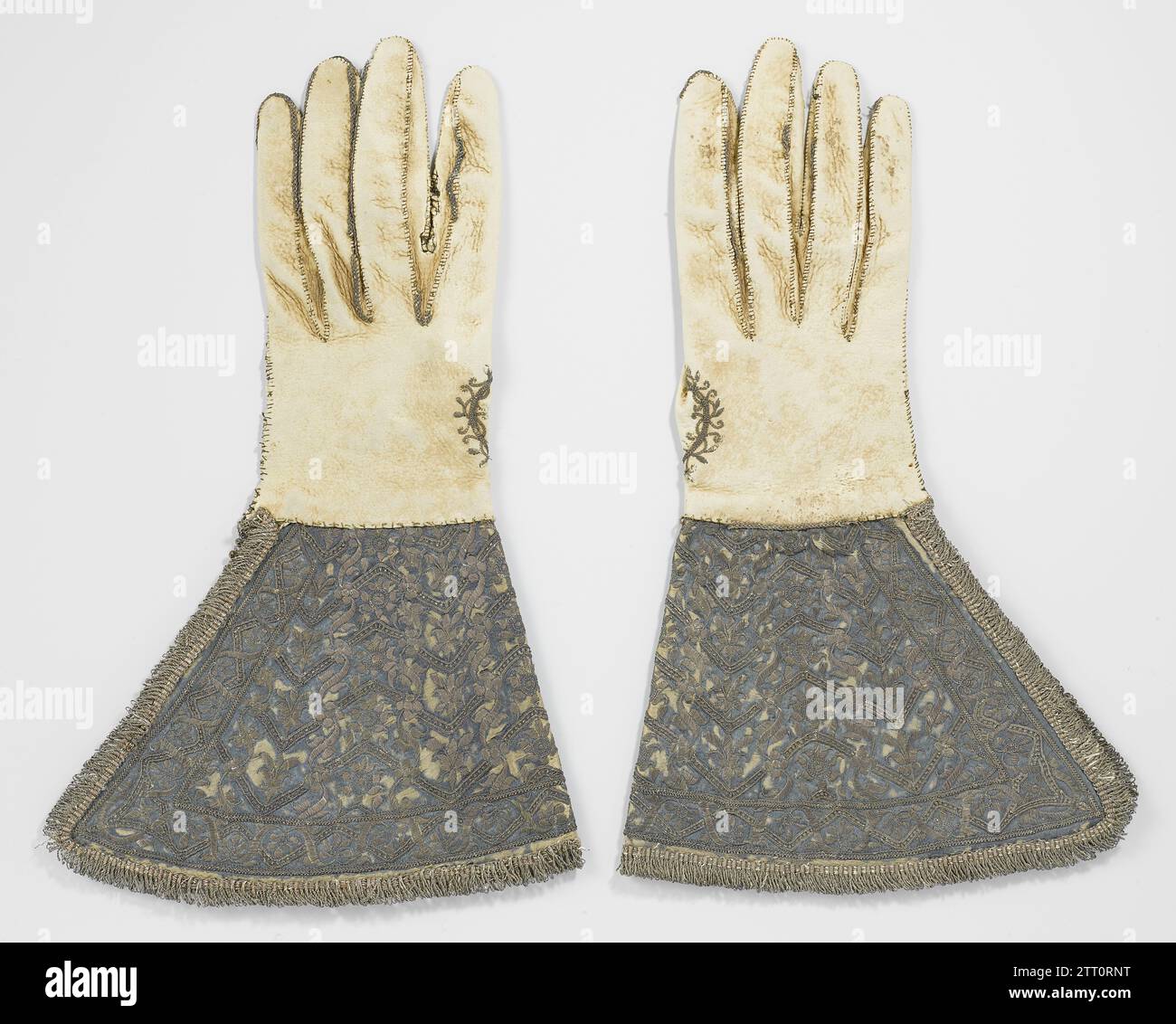 Gant de cuir à capuchons très larges, recouvert de satin bleu, brodé de fil d'argent et garni de volants d'argent, c. 1600 - c. 1610 gants de cuir à droite (pour hommes) à capuchons très larges, recouverts de satin bleu, brodés de fil d'argent et garnis de volants d'argent. Franning of loops, Deer (?) Cuir, broderie argentée autour du pouce. Angleterre (éventuellement) entier : cuir. Capuche : satin. Broderie : fil d'argent. FRACK : gants de coupe / broderie à droite (hommes) fil argent en cuir avec des casquettes très larges, recouverts de satin bleu, brodés de fil d'argent et garnis de s. Banque D'Images