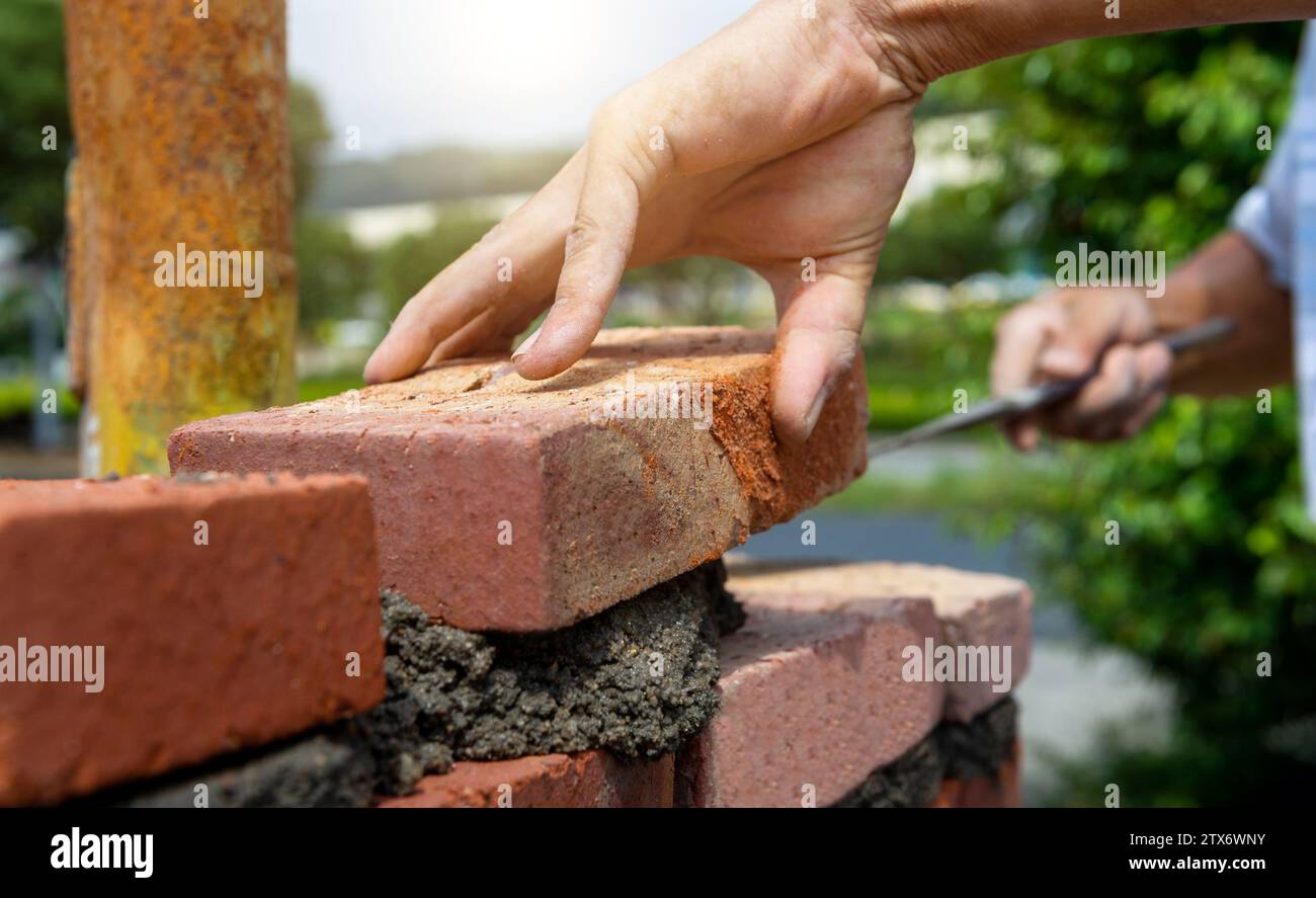 Constructeur posant des briques dans le chantier de construction Banque D'Images