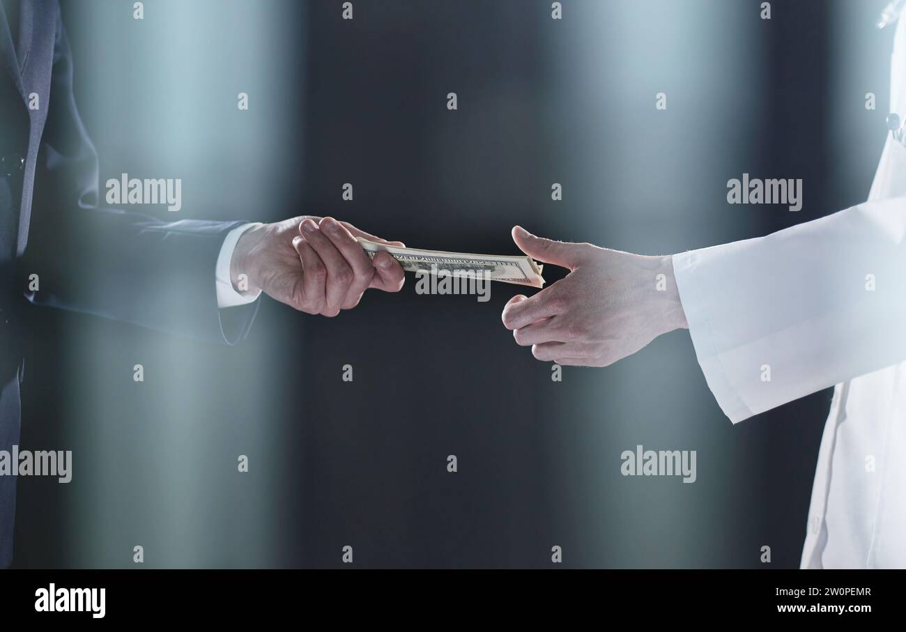 Homme offrant un lot de billets de cent dollars. Les mains rapprochées. Banque D'Images