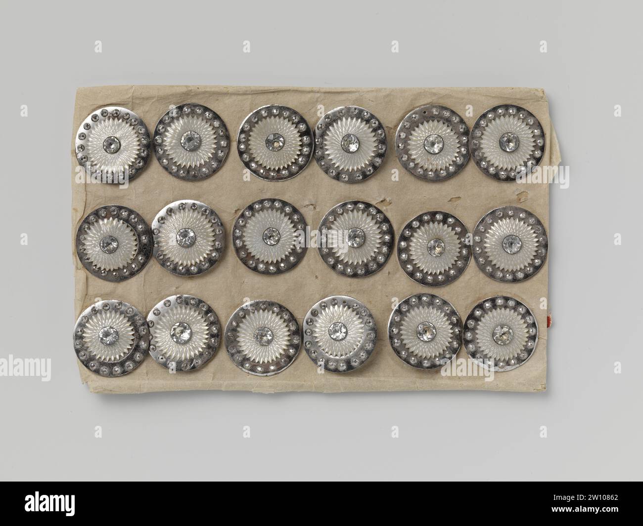 Carte bouton, anonyme, c. 1800 - c. 1825 dix-huit nœuds en acier poli avec une étoile perlée de paille de nacre couronnée d'une perle de Stras, scellée sur une carte de papier. La bague en acier poli est équipée de perles à facettes. Au-dessus de l'anneau l'étoile de nacre avec une perle de verre taillé facette sur métal (stras). Les boutons sont échantillonnés par une carte de papier épais et fixés à l'arrière et reliés par une corde qui est attachée et munie d'un polish de tuyau. Ces nœuds n'ont probablement jamais été utilisés et ont été offerts à la vente de cette façon. Allemagne (éventuellement) bouton : acier (alliage). Butto Banque D'Images