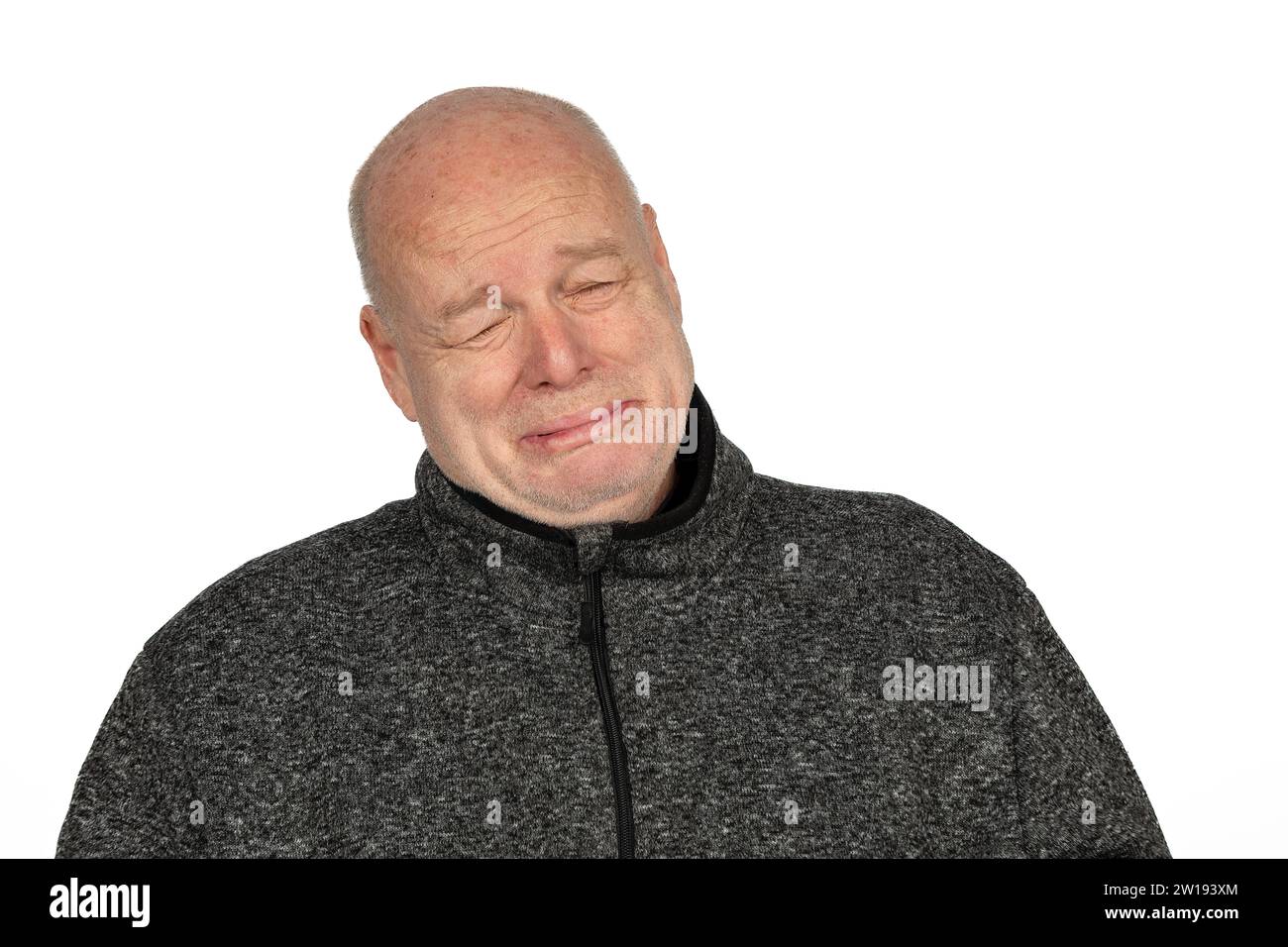 Homme caucasien émotionnel mature dans la veste de chandail gris pleurant sur fond blanc Banque D'Images