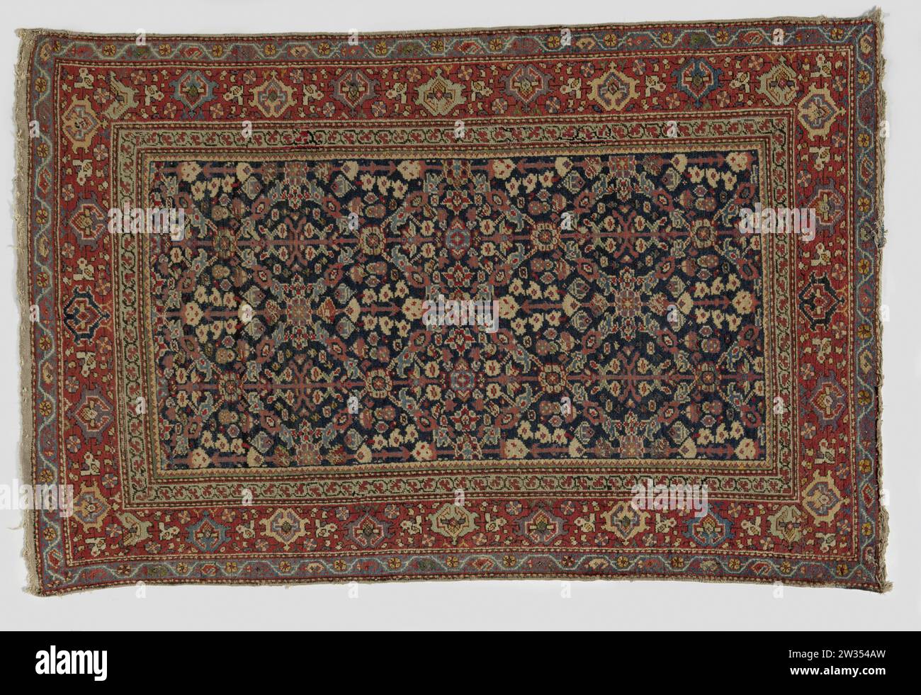 Tapis oriental ,, 1860 - 1880 tapis oriental. Au milieu du terrain, un motif quadrillé en forme de losange rempli de fleurs stylisées et de bouquets de fleurs sur un fond bleu foncé. Le bord du milieu est décoré avec un svelte, fleurs de lotus et rosettes. Middle Persia Katting an Element : tapis oriental en coton (textile). Au milieu du terrain, un motif quadrillé en forme de losange rempli de fleurs stylisées et de bouquets de fleurs sur un fond bleu foncé. Le bord du milieu est décoré avec un svelte, fleurs de lotus et rosettes. Middle Persia Katting an Element : coton (textile) Banque D'Images