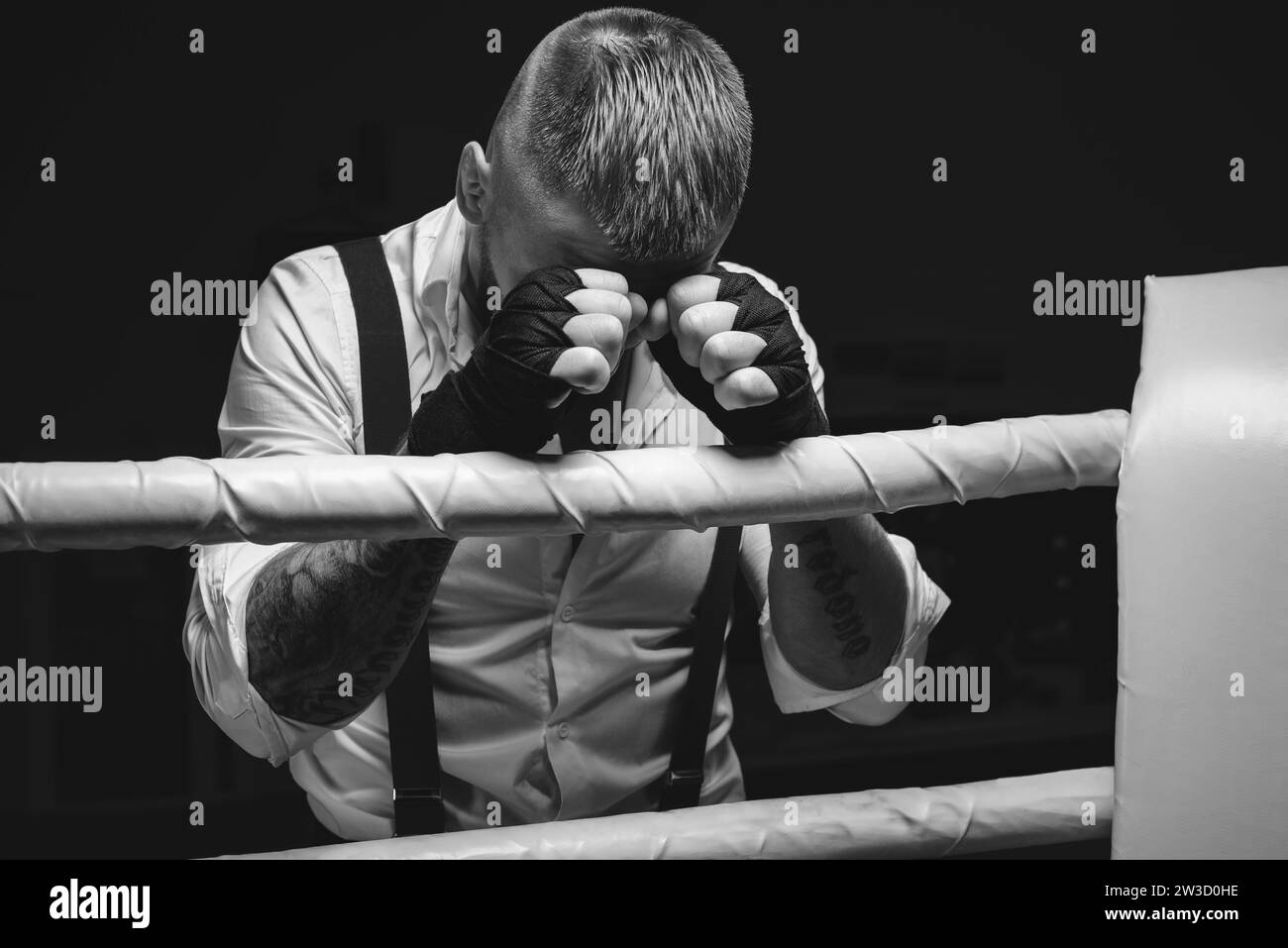 Image d'un homme brutal debout près des cordes de l'anneau. Il prie avant le combat. Le concept de combats de poing. Supports mixtes Banque D'Images