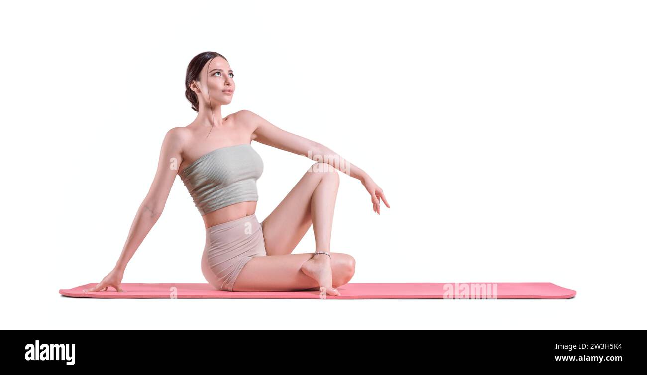 Jeune femme sportive pratiquant le yoga. Le concept d'un mode de vie sain et d'un équilibre naturel entre le corps et l'esprit. Pilates, étirements. Supports mixtes Banque D'Images
