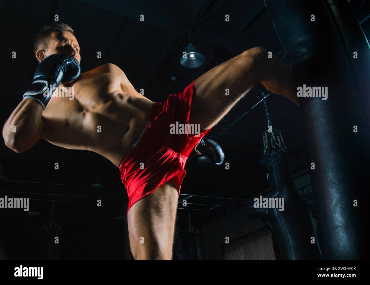 Sportif professionnel des arts martiaux mixtes se tient après le combat gagné près du sac et regarde de manière menaçante son prochain adversaire Banque D'Images