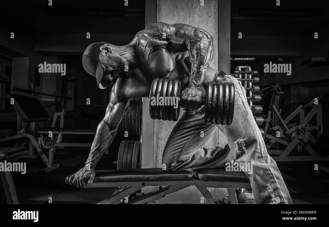 L'homme musclé tire un haltère vers son estomac. Concept de culturisme et de levage hydraulique. Supports mixtes Banque D'Images